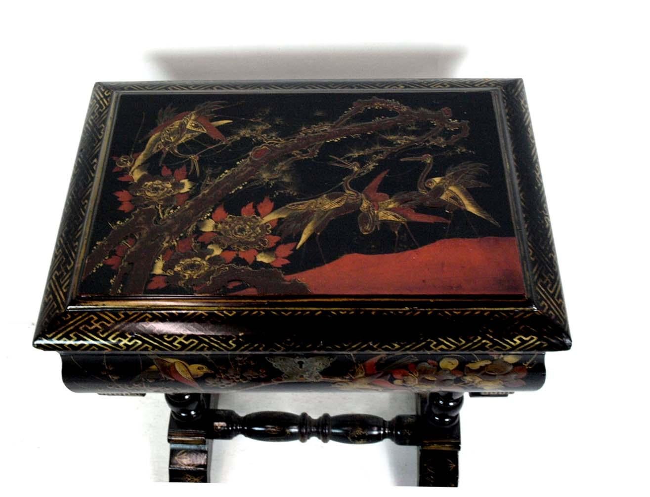 Japanese lacquer sewing table, the top and front decorated with words and flowers, the interior fitted with compartments and pin cushions, the box resting on two turned legs with connecting stretcher. Note the butterfly shaped escutcheon.