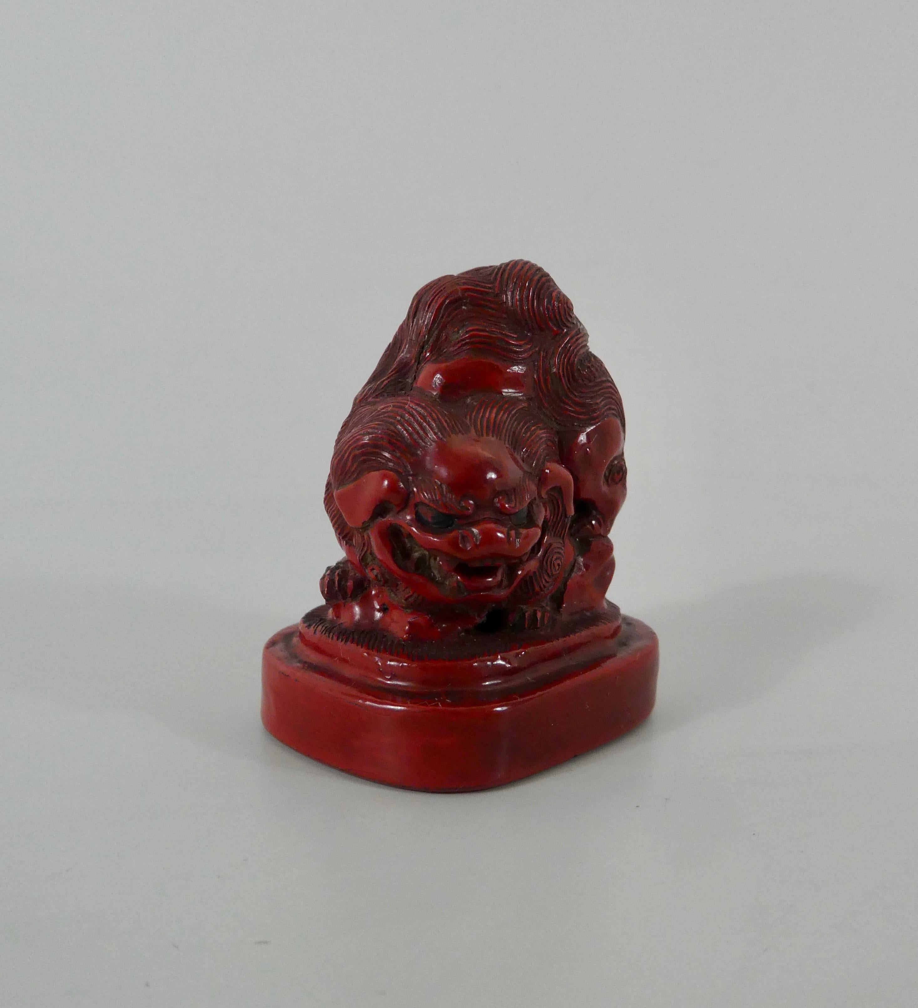 Japanese red lacquer (tsuishu) Shishi dog netsuke, early 19th century, Edo Period. The finely detailed dog, clambering over a rock, and set upon a stepped and shaped oval base. The himotoshi formed through the rock, and the base.
Measures: Height -