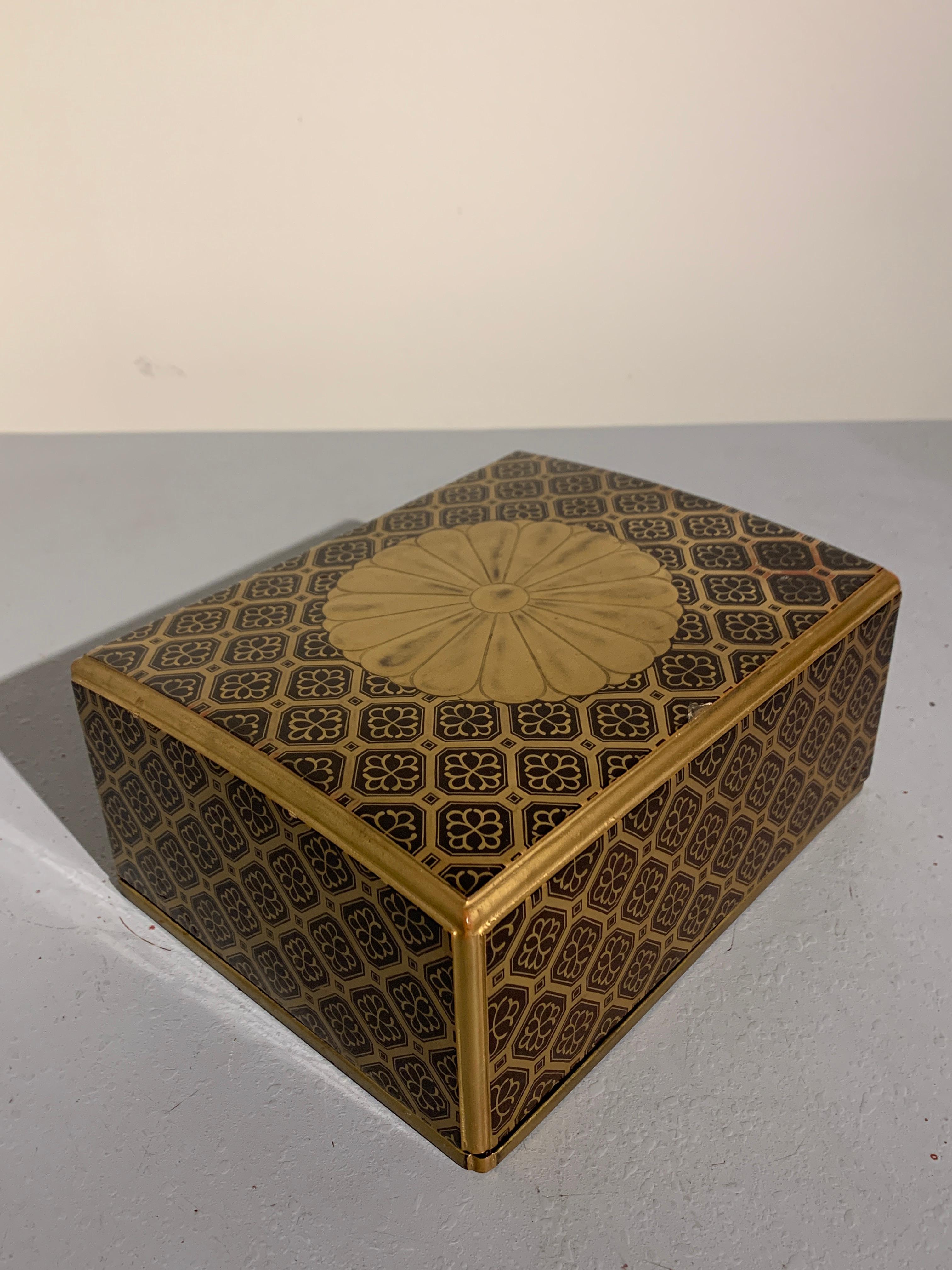 A fine and elegant Japanese sutra box, called a kyobako, in black and gold lacquer, featuring a large imperial sixteen petal chrysanthemum mon against a raised gold lacquer diaper ground, Edo period (1603-1868), late 18th century.

The imperial