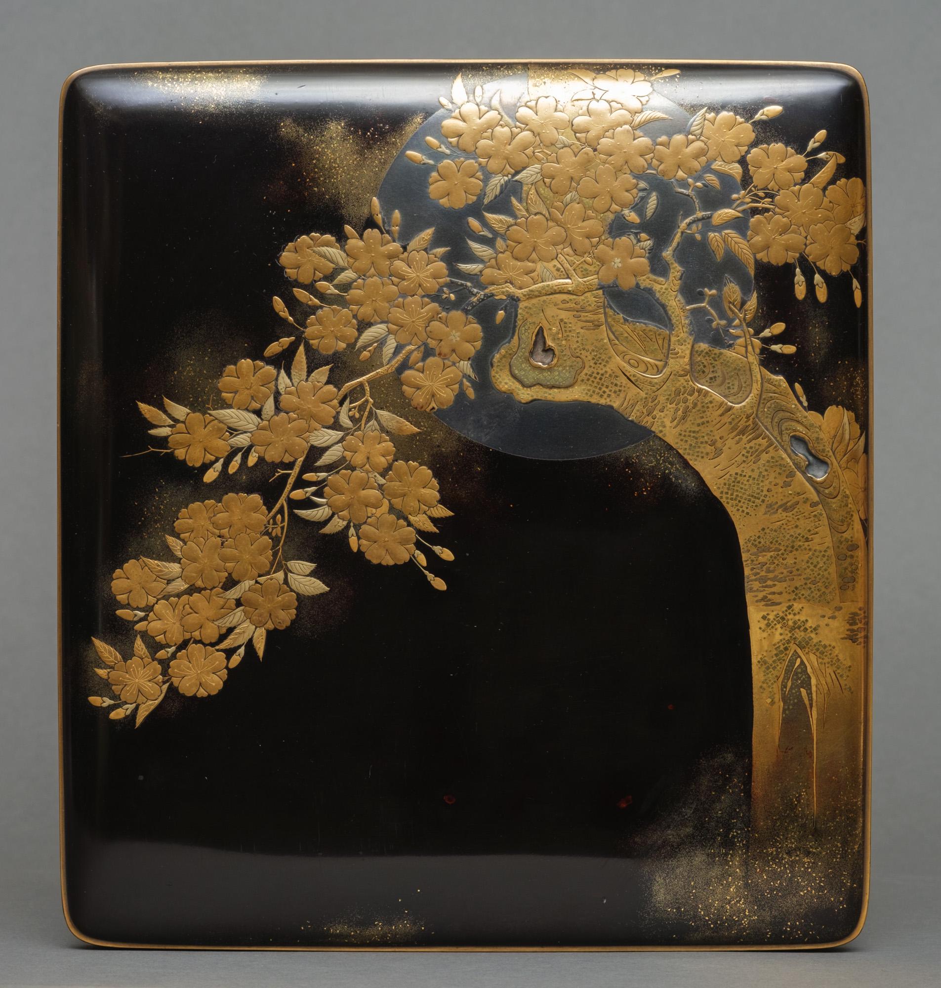 A very well-made, beautiful black lacquer rectangular suzuri’bako (writing box) with rounded corners. The well-fitted overhanging cover with a design of a lush cherry blossom tree (sakura) in full bloom with prominent recessed burls, and with a