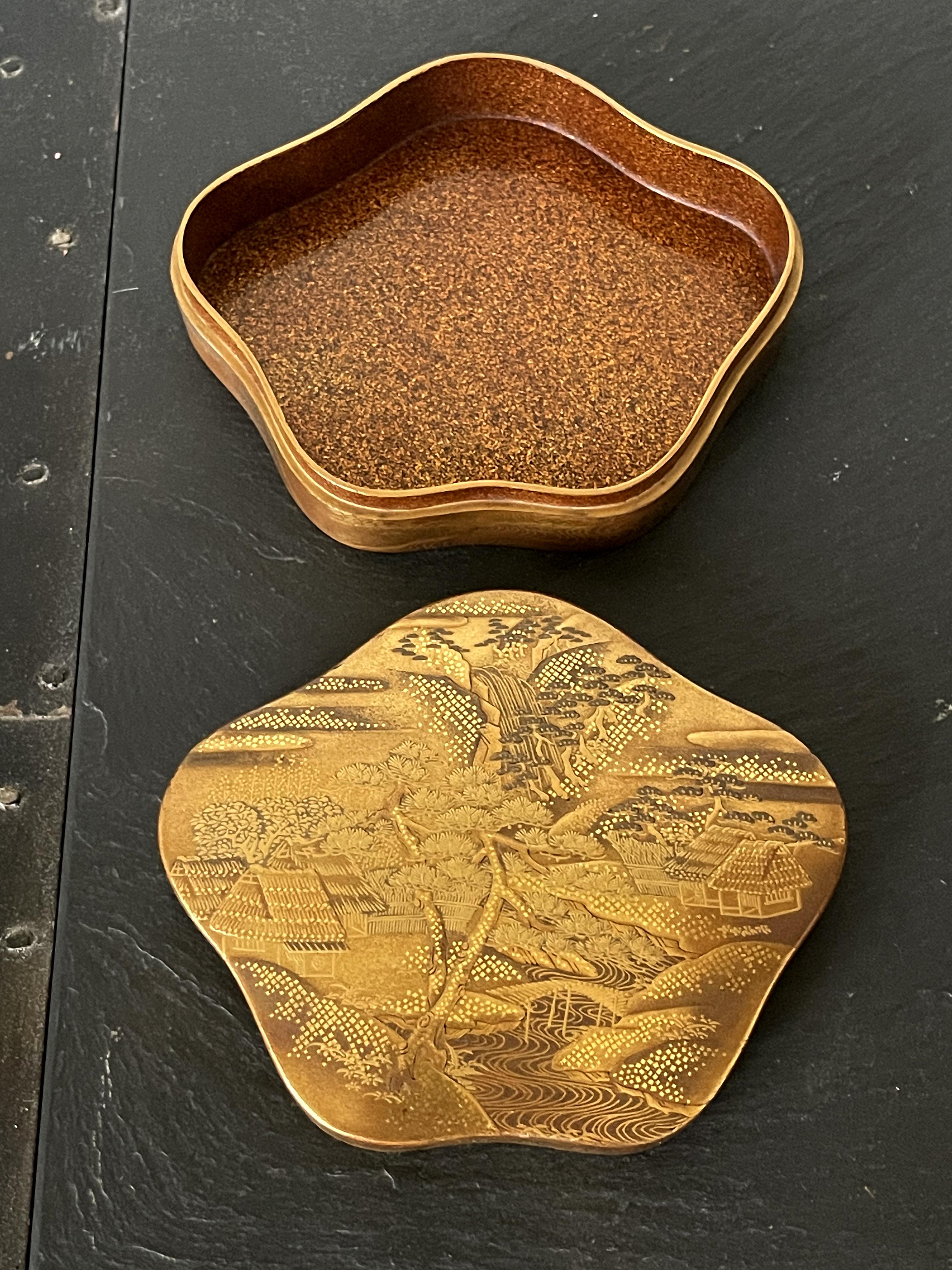 A lovely Japanese Maki-e lacquer box circa 1900s late Meiji period. The small box takes an slightly unusual organic shape that is reminiscent of the five petal cherry flower Somei Yoshino. The cover of the lid is lavishly decorated with Hiramakie,