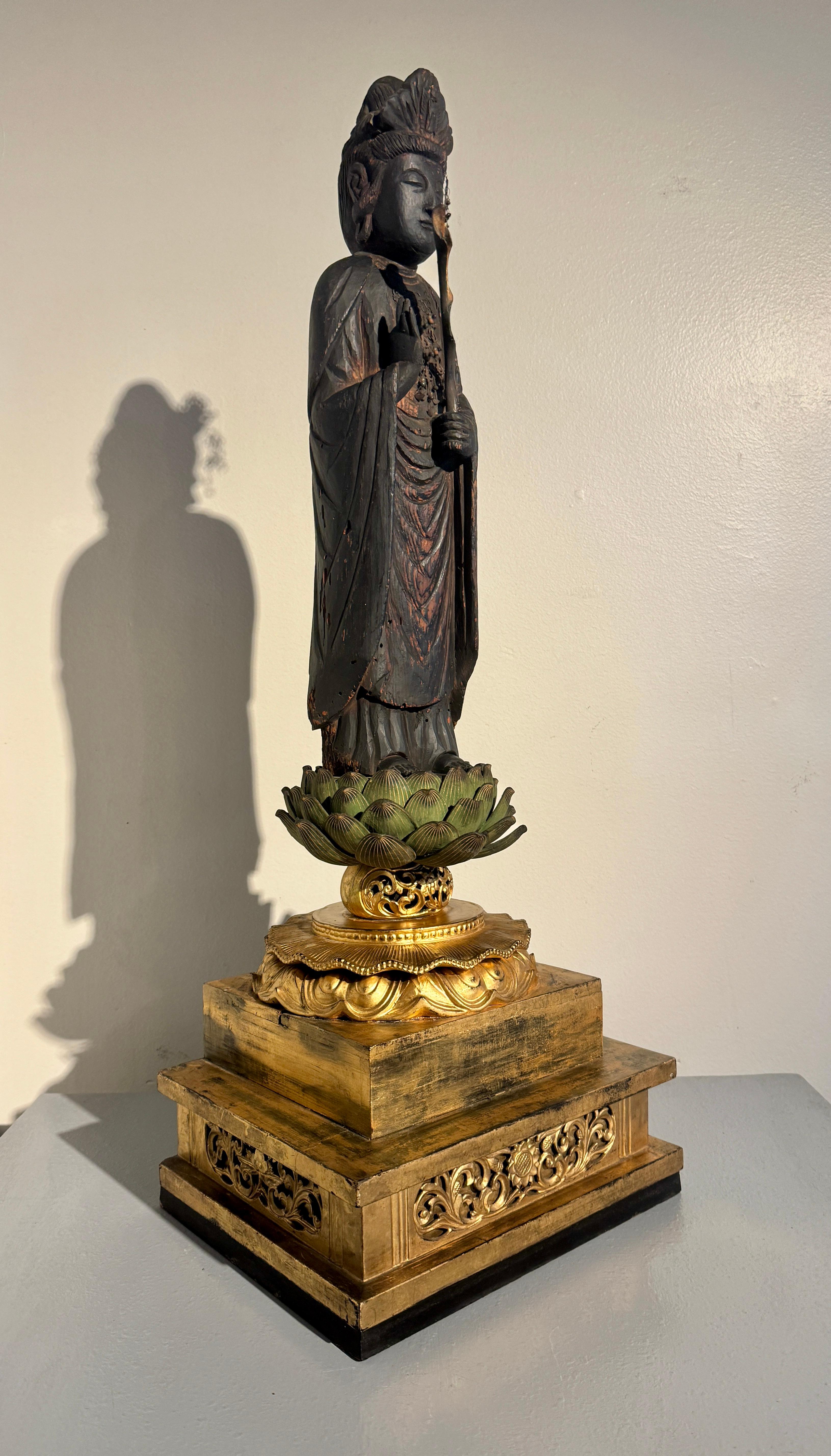 Alta e impresionante figura japonesa tallada y lacada en negro de Sho Kannon Bosatsu, Periodo Momoyama o Edo, mediados del siglo XVII, sobre una base pedestal de loto de madera tallada, pintada y dorada, posterior, de mediados del siglo XIX. 

La
