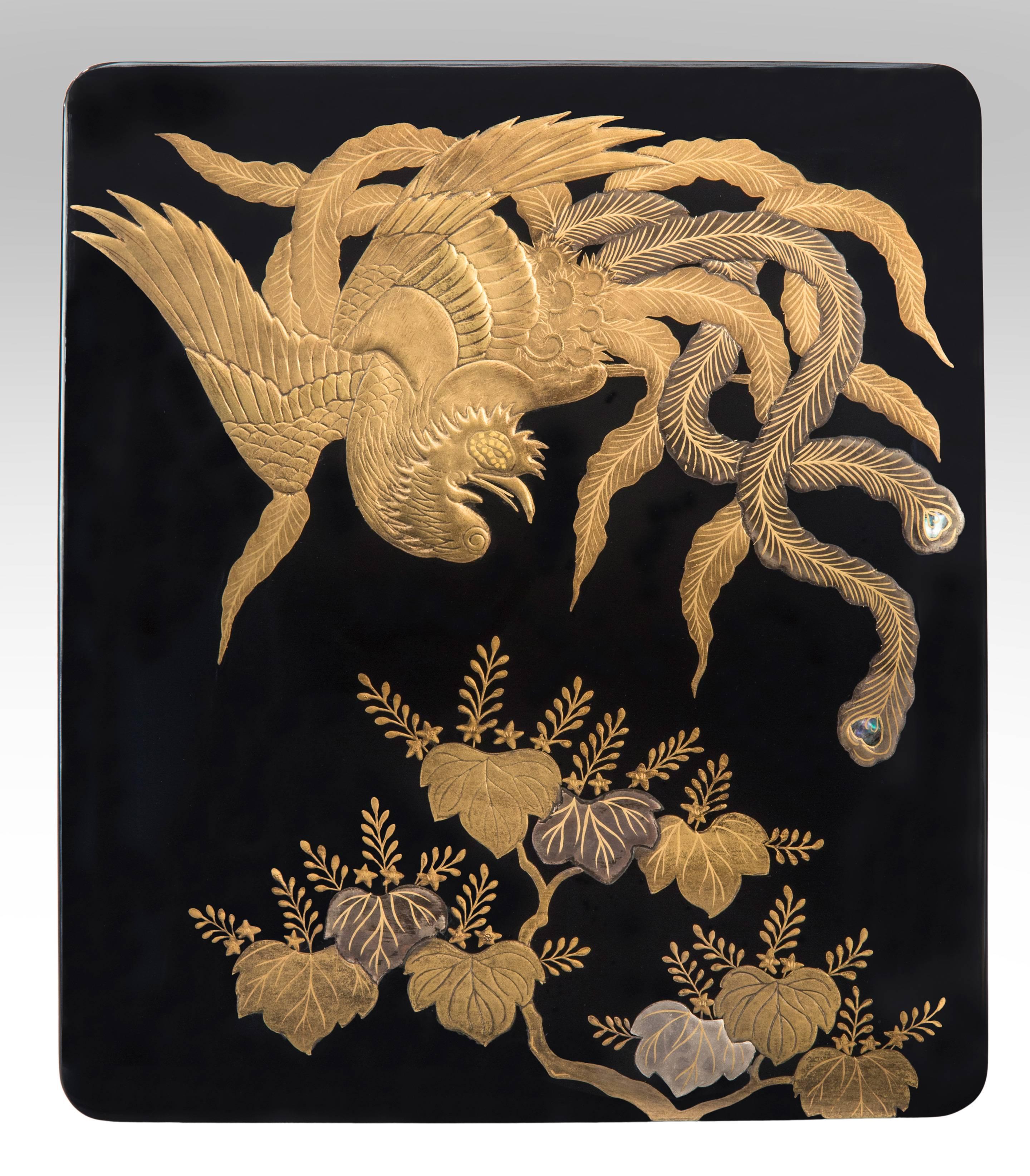 Japanese lacquerware writing box with a phoenix motif
Meiji period, late 19th century or early 20th century.
The rectangular top depicting a golden phoenix with mother-of-pearl inlays, floating above mulberry leaves against a black lacquer