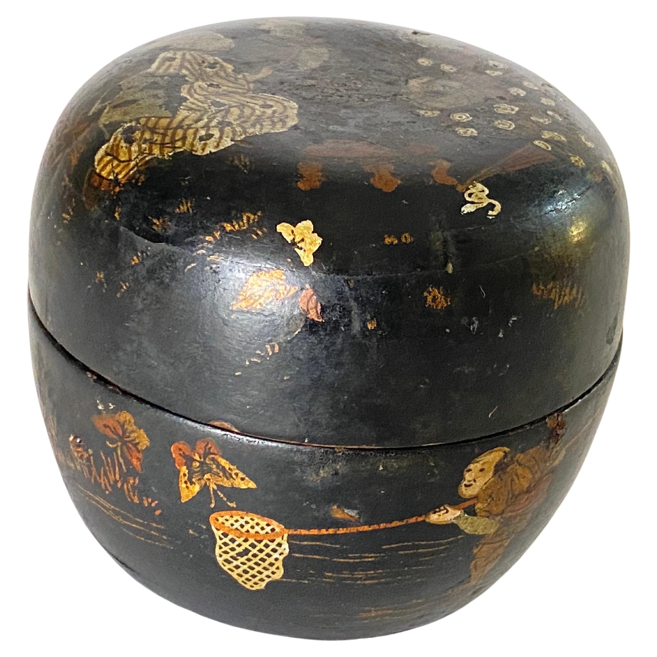 This is a beautiful papier mâché, circular lacquered lidded box, which we attribute to being made in Japan during the early 20th century, circa 1910.

This is a very decorative box with a delicately hand-painted scene. The base color is black with