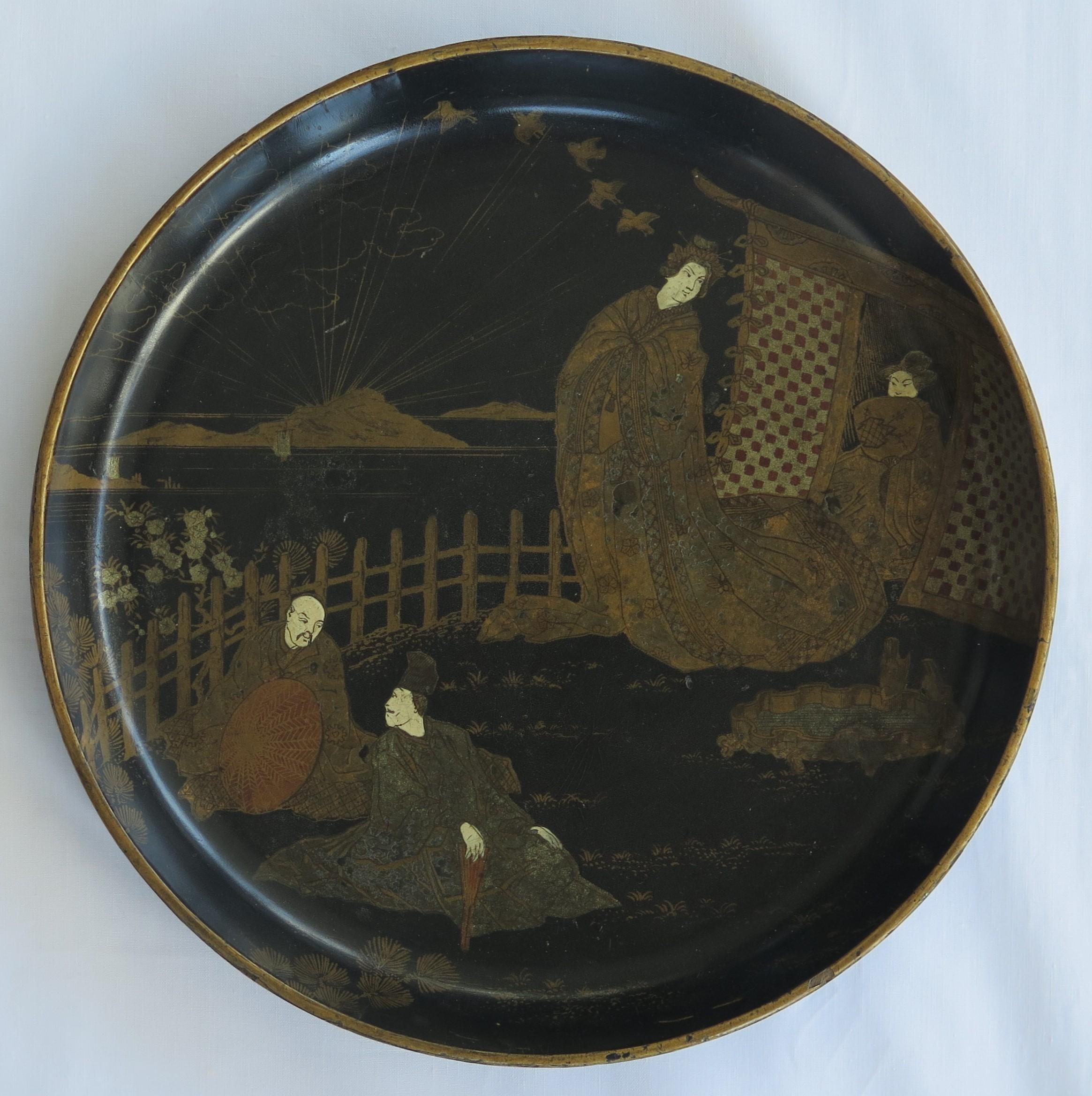 This is a good papier mâché, circular, black lacquered tray, hand enameled and gilded, made in Japan during the 19th century, Meiji period.

This circular tray is very decorative, with a finely hand painted scenes of four people in an outdoor