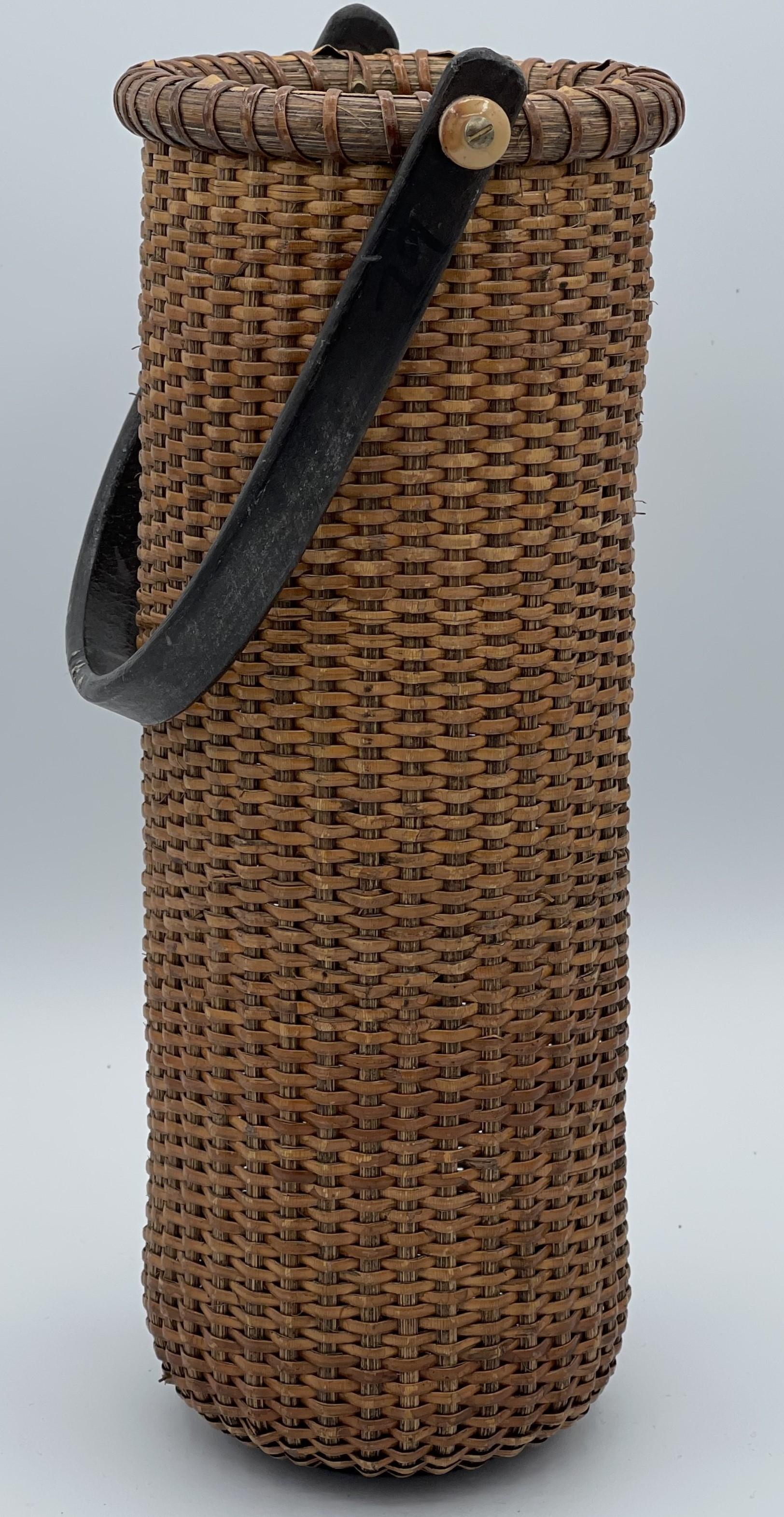 Elegante cesta de bambú tejido de finales del periodo Meiji, de principios del siglo XX. Esta pieza alta y finamente elaborada ejemplifica el arte y la maestría técnica del tejido de bambú japonés. Su forma alargada y cilíndrica y su dibujo uniforme
