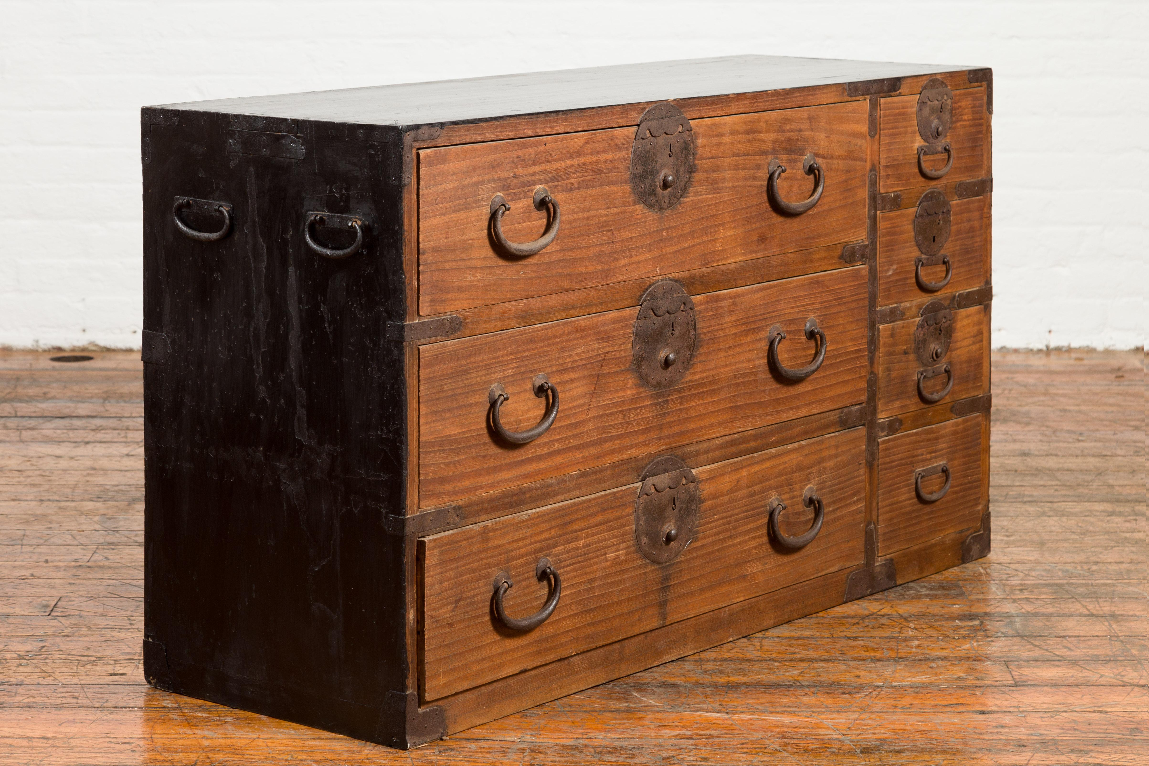 A Japanese late Meiji period keyaki wood tansu chest from the late 19th century, with seven drawers and iron hardware. Created in Japan during the Meiji period, this keyaki tansu chest features a rectangular top sitting above seven drawers fitted