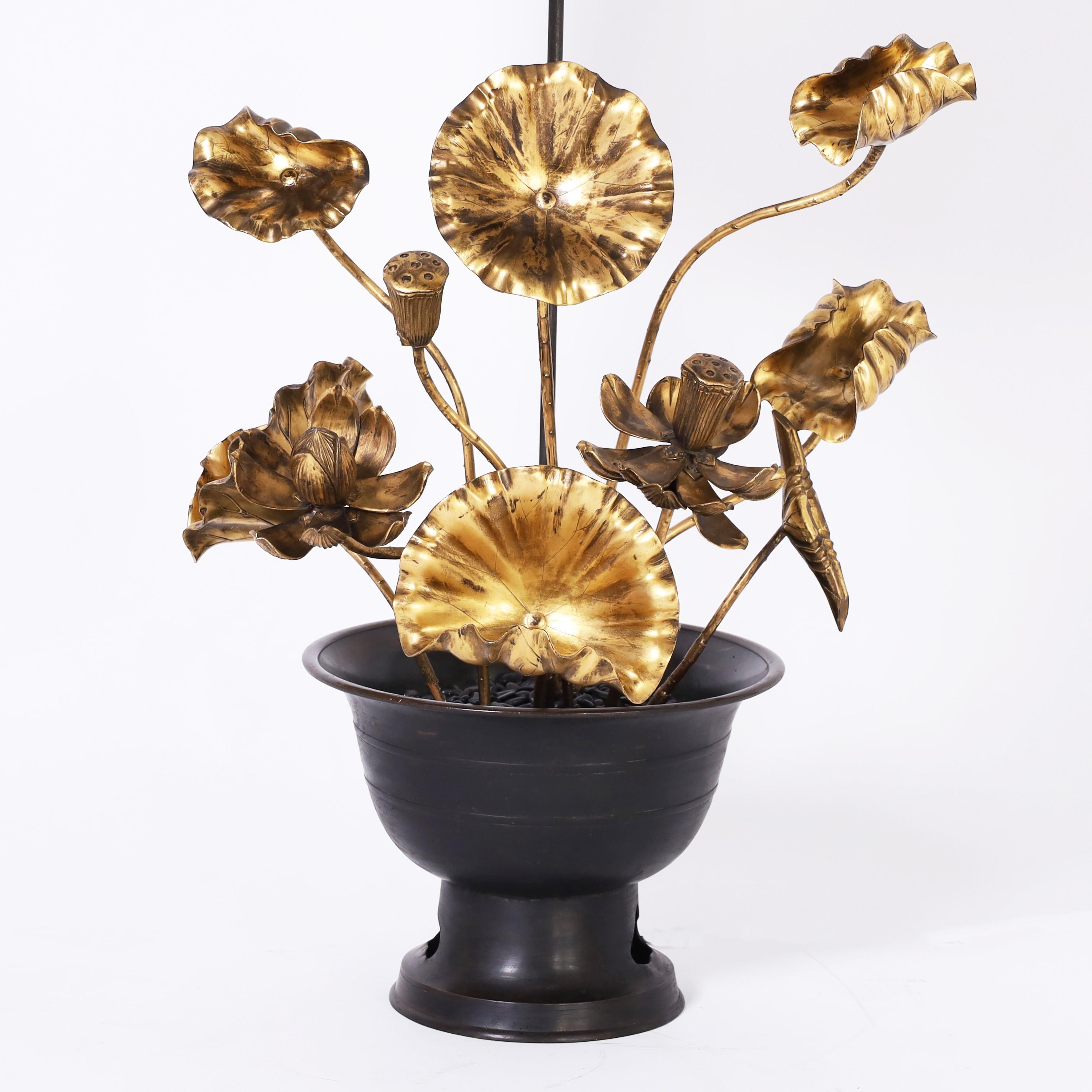 Standout mid century Japanese table lamp having hand carved wood lotus leaves and flowers with a gilt finish, in a classic bronze urn with black stones in the top.