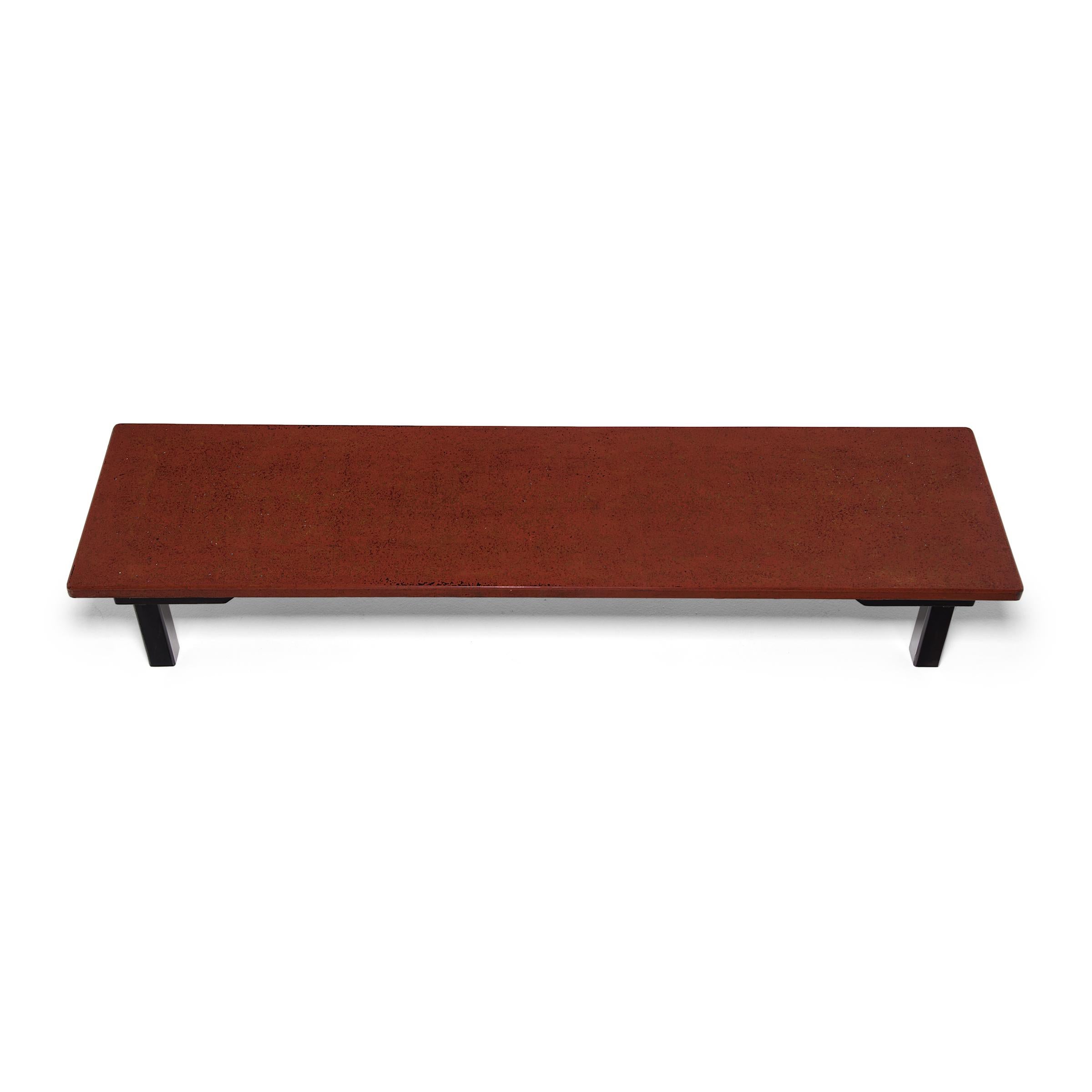 The restrained silhouette of this low Japanese table beautifully showcases the extraordinary patterning of the lacquered table top. In a traditional lacquer technique known as tsugaru-nuri, red lacquer flecked with bits of shell and gold powder was
