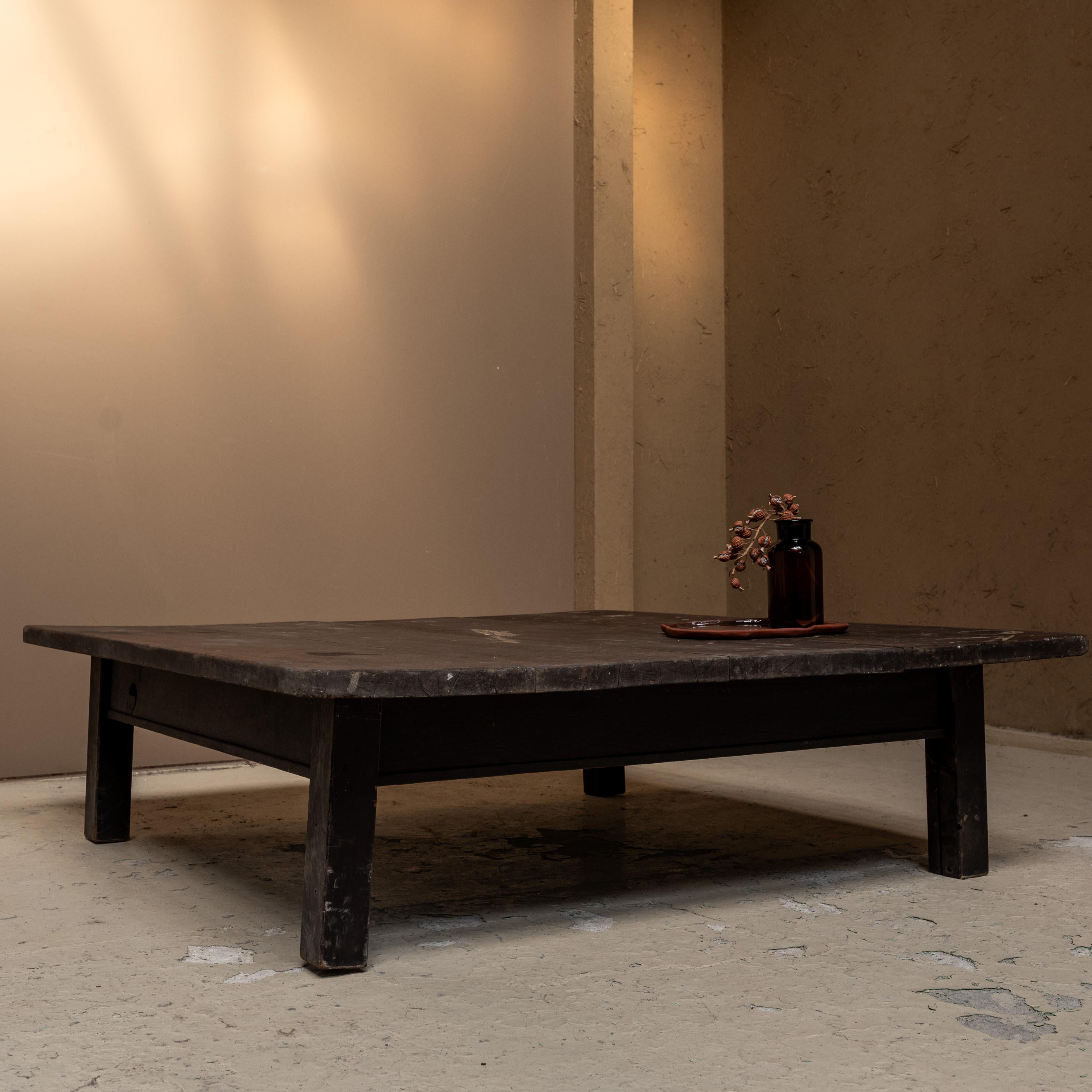 Der antike niedrige Tisch, der aus altem japanischem Holz gefertigt wurde.
Die obere Platte wurde grob rasiert und weist verschiedene Spuren und Kratzer auf, die von seiner Geschichte erzählen. 

Seine unvollkommenen Formen schaffen eine