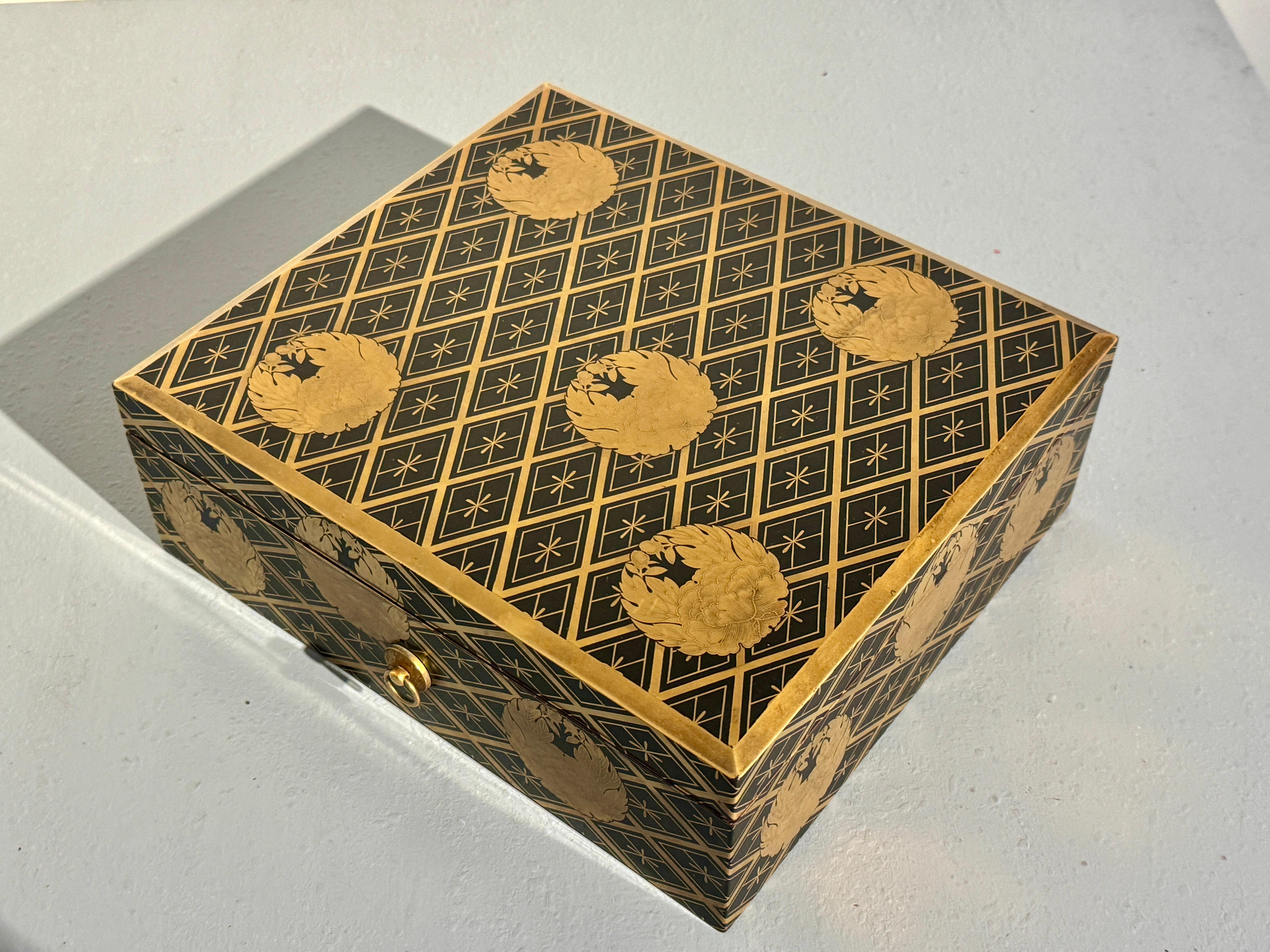 A Japanese maik-e decorated black lacquer sutra box, kyobako, with peony mon design, Meiji Period, circa 1900, Japan.

The elegant lacquer box originally crafted to hold sutras, sacred Buddhist texts. Of rectangular shape, the lacquer box features a