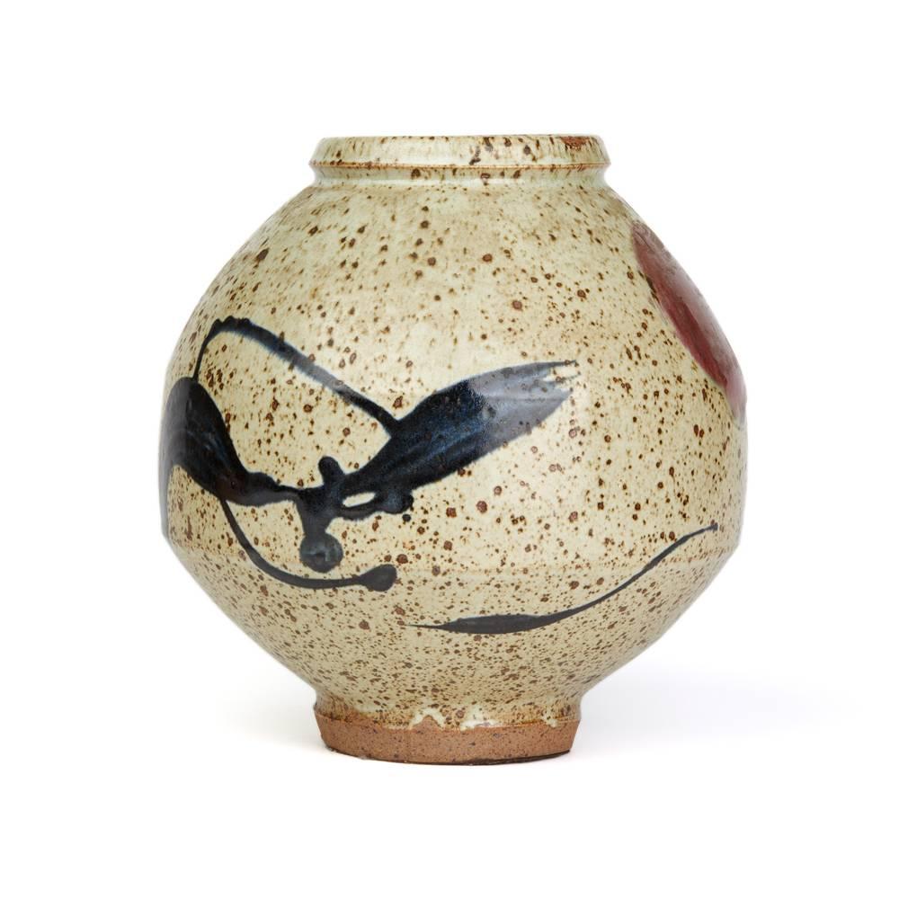 A stunning and stylish Studio Pottery vase, believed Japanese, of large bulbous shape decorated with stylized dancing figures in brushed glazes on a stone colored ground with tenmoku glaze spotting. The vase has an unglazed foot with an impressed