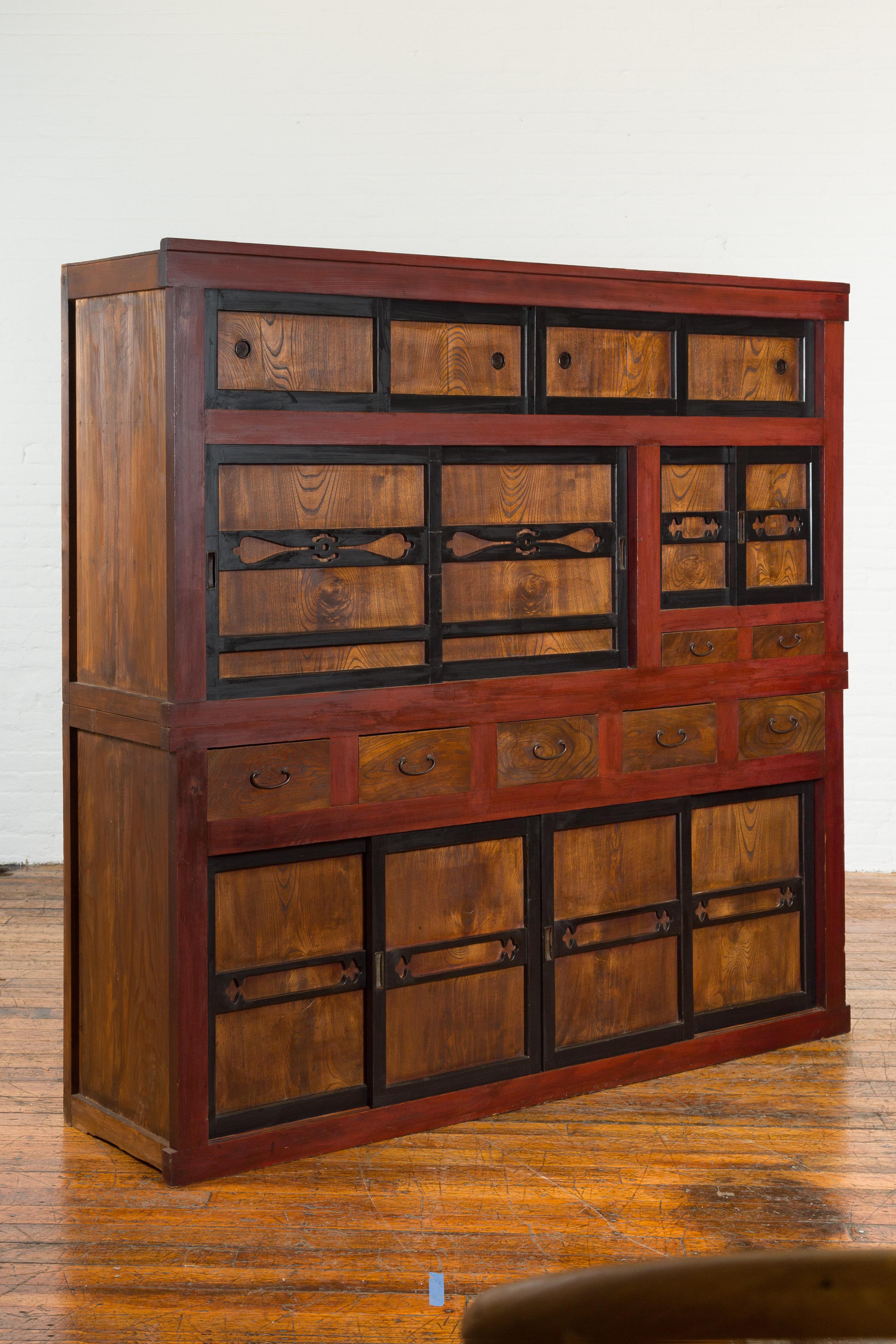 A large Japanese Meiji period kitchen cabinet from the early 20th century, with cinnabar and black patina and sliding doors with natural wood grain. Created in Japan during the Meiji period, this cabinet is great for dining room or kitchen storage!