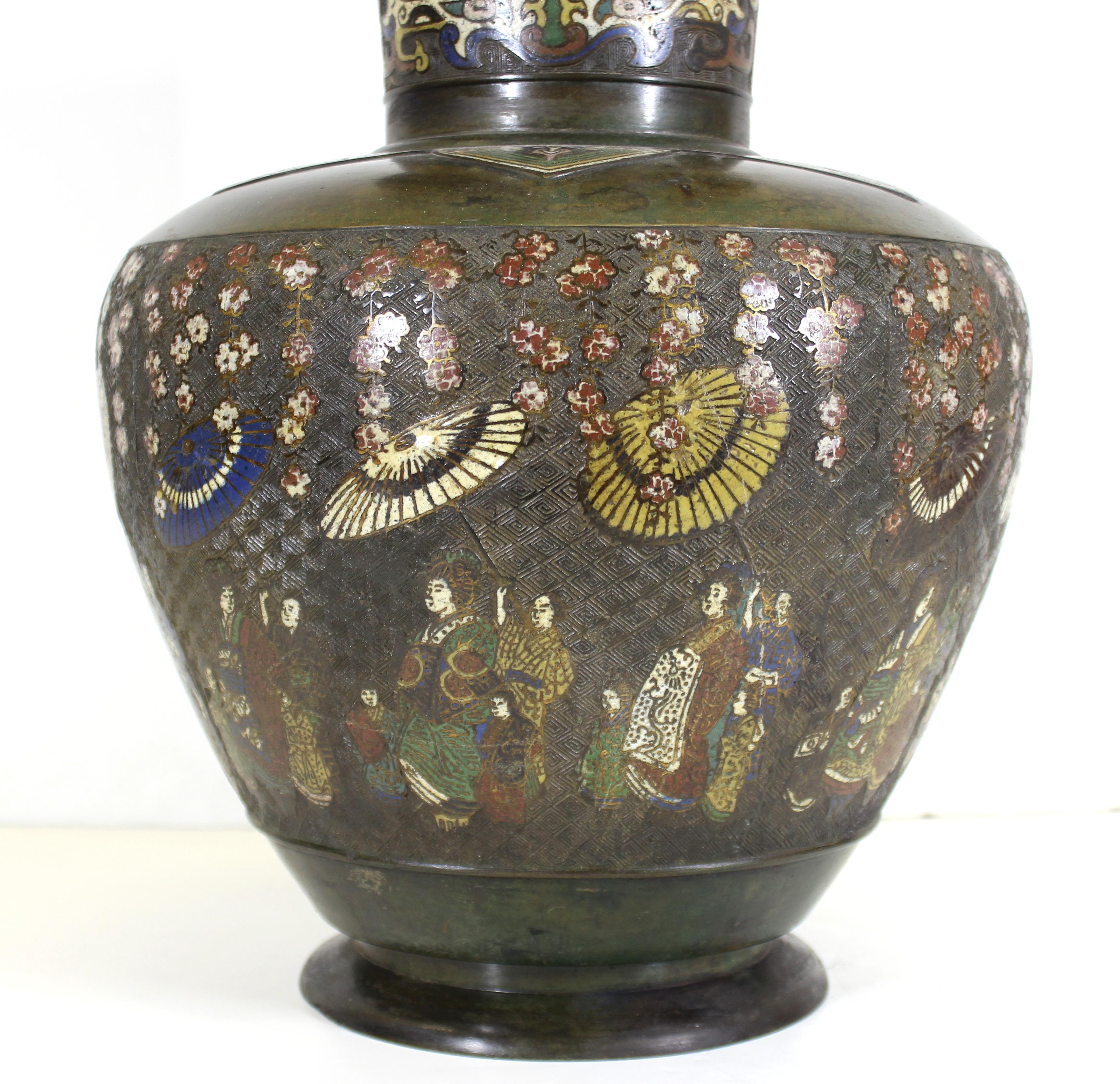 Japanese Meiji period archaic Chinese revival bronze vase with champlevé enamel scenes with geishas walking with parasols in a garden. The piece was made in the 1900s in Japan. The inside bottom features a relief with a crane in a garden. In great