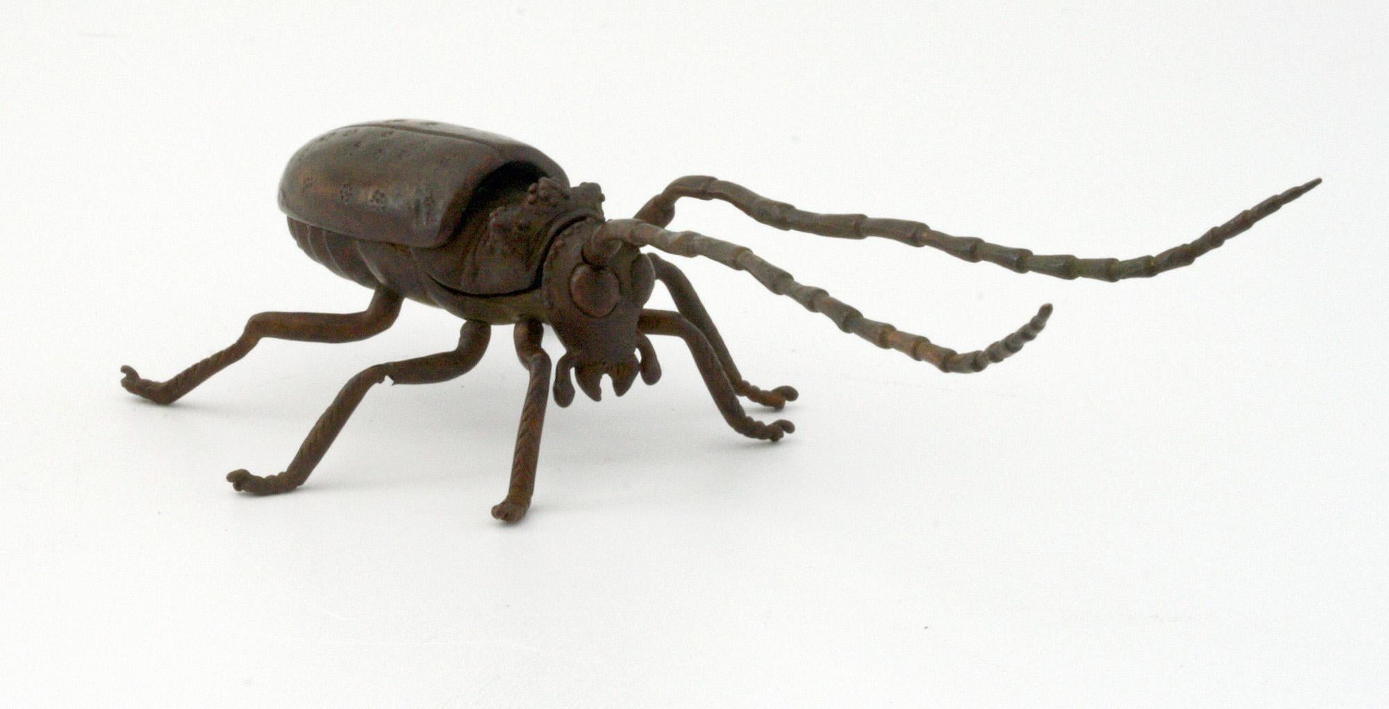 A scarce and finely made antique Japanese Meiji bronzed articulated figure of a flying beetle dating from the latter 19th century. The well detailed insect stands on its six legs, all freely moving and has two long antennae which also move with a