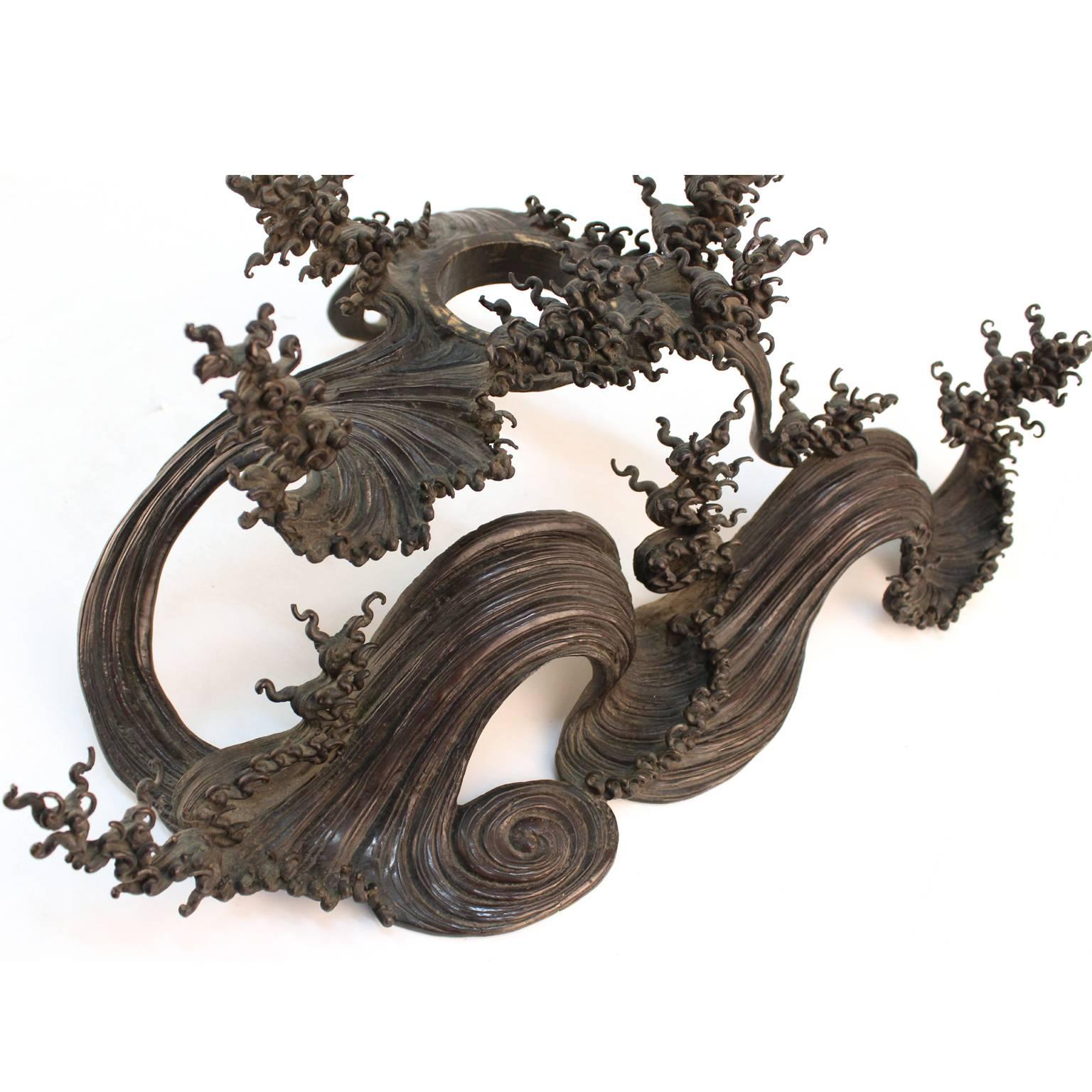 An exceptional Japanese Meiji-era bronze Ikebana vessel atop a moving-wave shaped base. Very good original condition, no signature or marks.