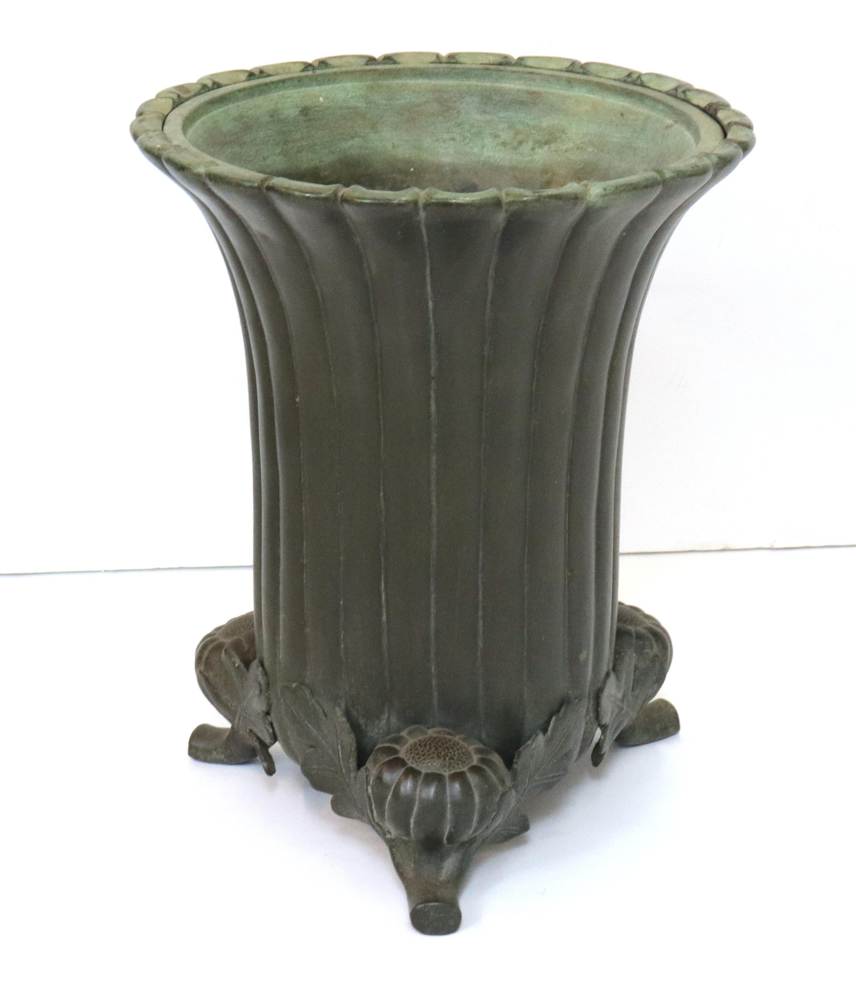 Japanese Meiji period ikebana vessel made in bronze with a decorative tripod base featuring Chrysanthemum blossoms on stems. The piece has a channeled green patina and was likely made during the late 19th century.
In great antique condition with
