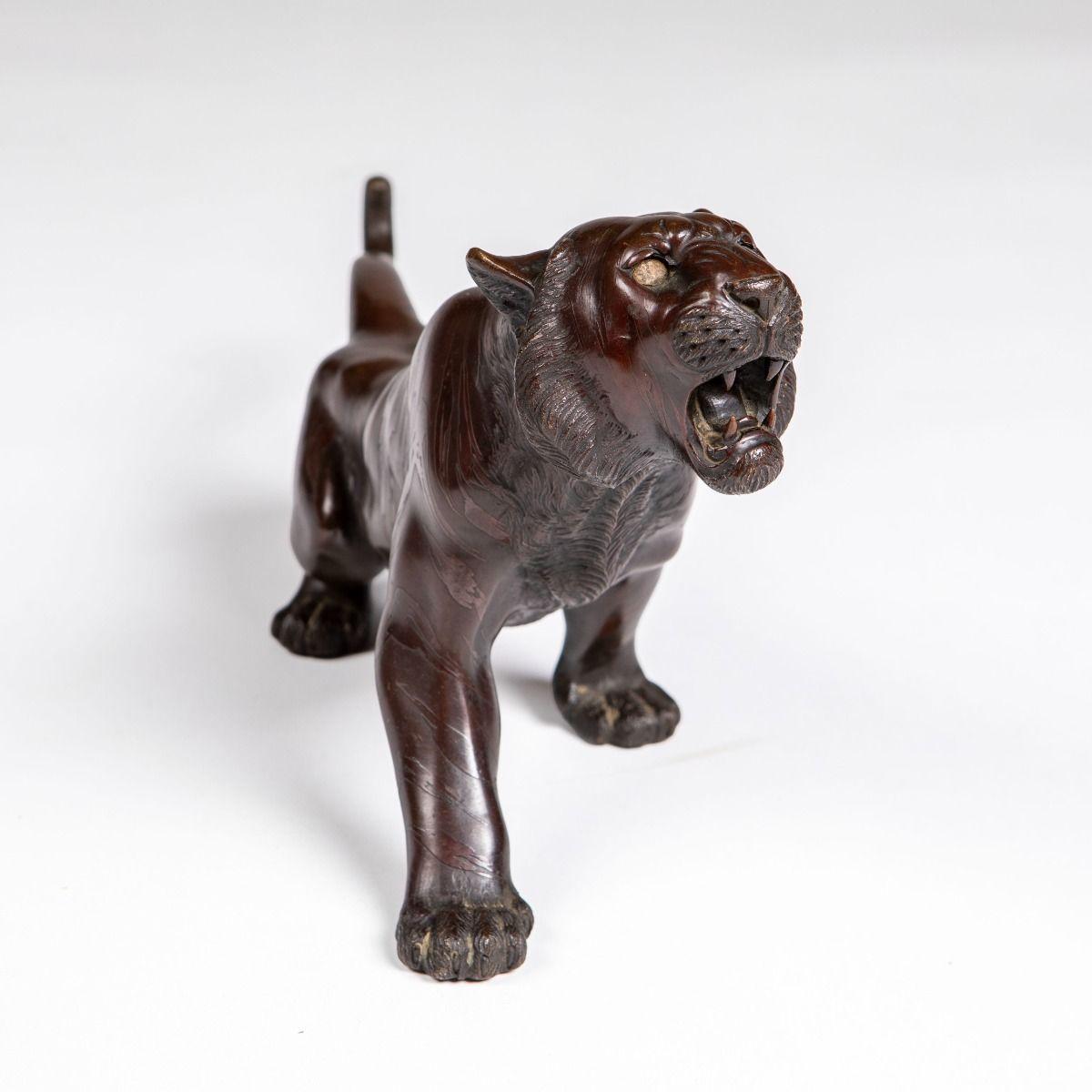 tigre en bronze de l'apanage de l'époque Meiji, à la patine chaude brun-rouge.
La pièce est fabriquée selon des normes élevées, modelée avec des proportions réalistes dans une pose dynamique en mouvement vers l'avant, avec une bouche ouverte, une