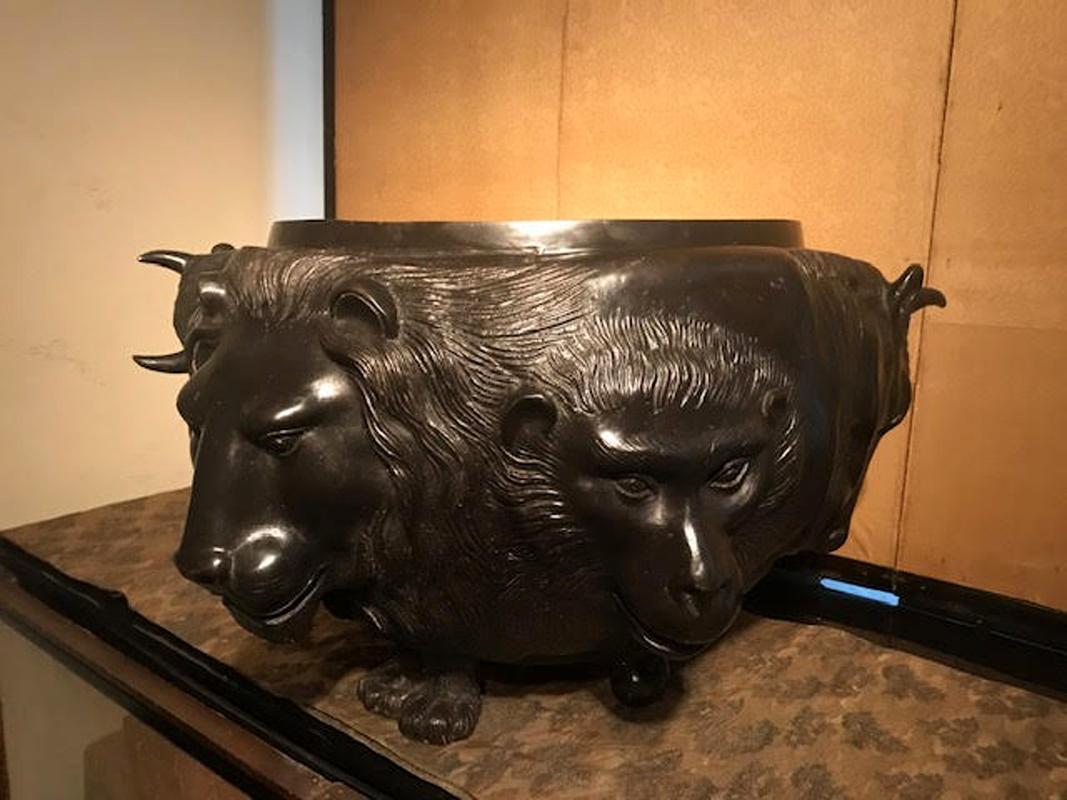Japanese Meiji period bronze vessel with elaborately sculpted animal heads. Lion, ape and bull heads are surrounding the vessel. Made in Japan in the circa 1880s, the piece has a makers mark and a rich dark bronze patina. In great antique condition