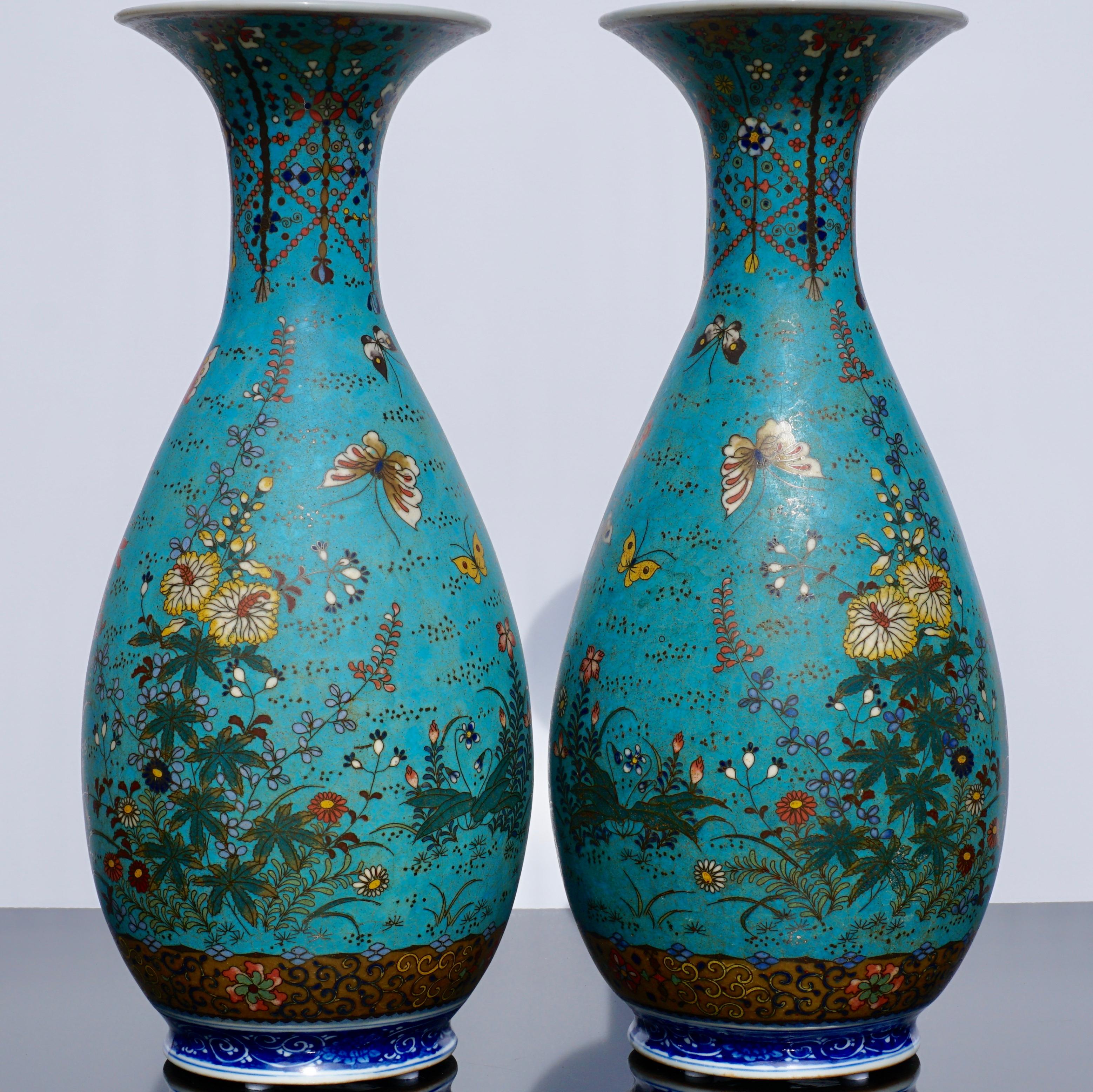 A rare pair of silver wire cloisonné enameled porcelain vases

Signed Dainihon Seizo Shippo Gaisha Kojin Takeuchi Chubei, Meiji period (late 19th century)

Each of bulbous form with tall everted neck, the porcelain body over-enamelled in various