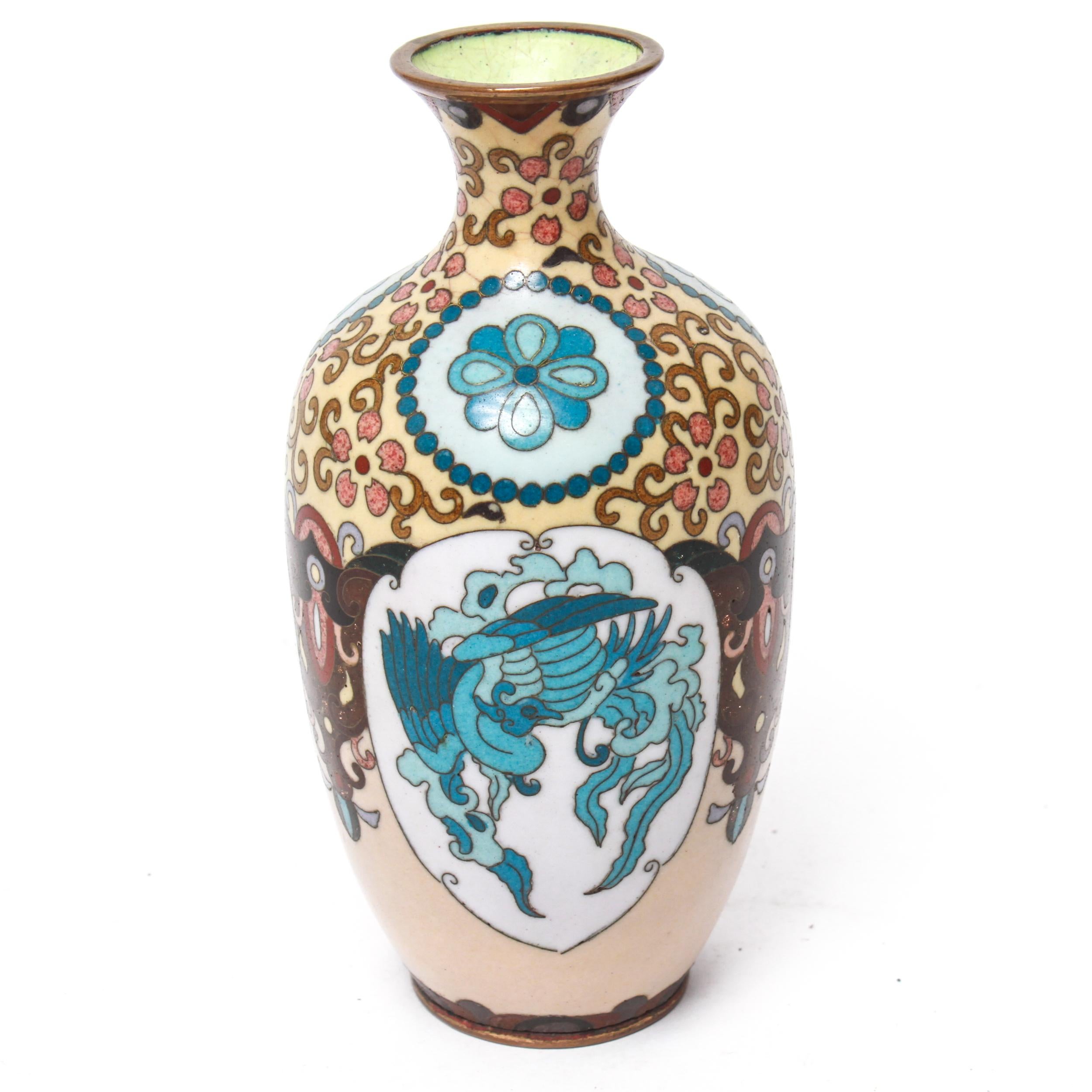 Japanese Meiji period cloisonne bud vase with floral, vine, and geometric patterns in enamel. The underside and interior of the vase have chartreuse glazing. The piece was made in the 19th century and is in great antique condition with