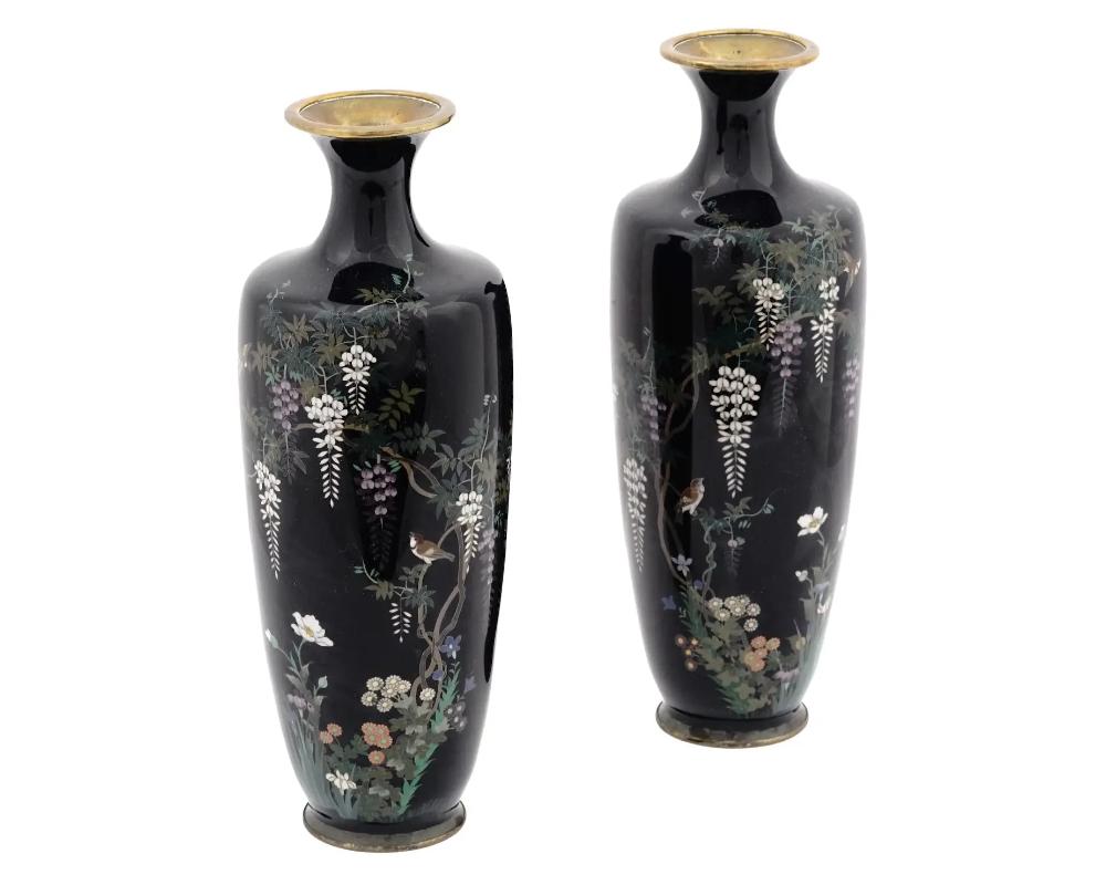 A pair of antique Japanese copper vases with cloisonne enamel design. Late Meiji era, before 1912. Elongated shape with pronounced neck. The pieces are decorated with wisteria flower motif against the black background. High quality. Collectible