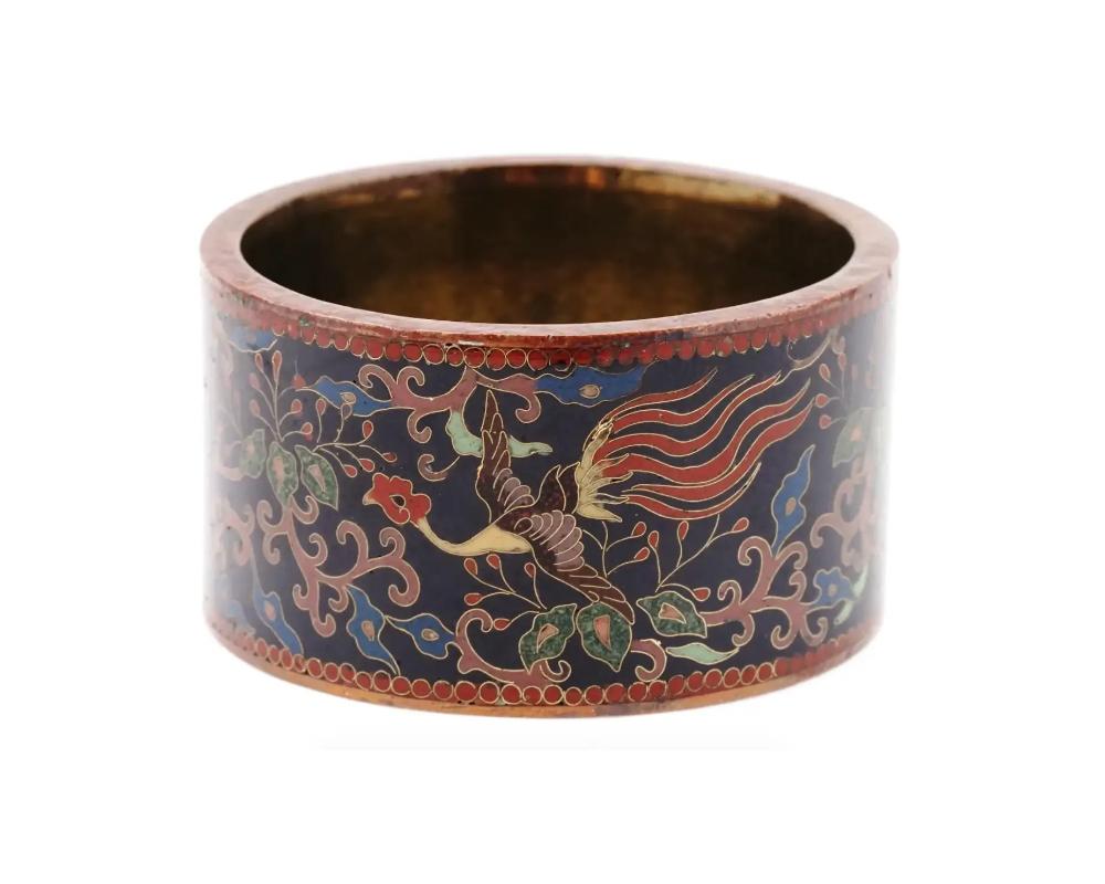 An antique Japanese Meiji Era copper and enamel napkin ring. Circa: early 20th century. The ware is enameled with polychrome images of Phoenix birds surrounded by foliage, and scrollwork patterns made in the Cloisonne technique. Unmarked. The