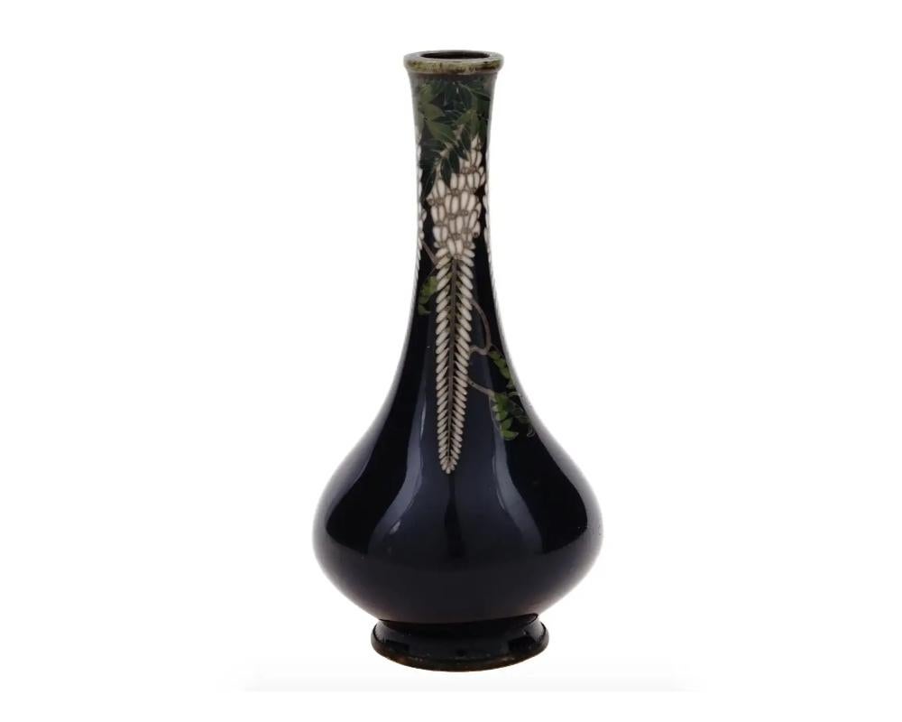 An antique Japanese copper vase with cloisonne enamel design. Late Meiji period, 1868 to 1913. Miniature dark cobalt blue vase with a round body and long neck. The neck is decorated with wisteria flowers. Embossed flower signature on the bottom.