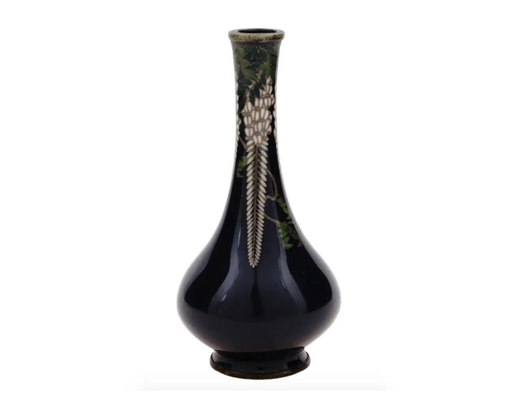 Un antico vaso giapponese in rame con smalto cloisonne. Tardo periodo Meiji, dal 1868 al 1913. Vaso in miniatura blu cobalto scuro con corpo rotondo e collo lungo. Il collo è decorato con fiori di glicine. Firma con fiore in rilievo sul fondo.