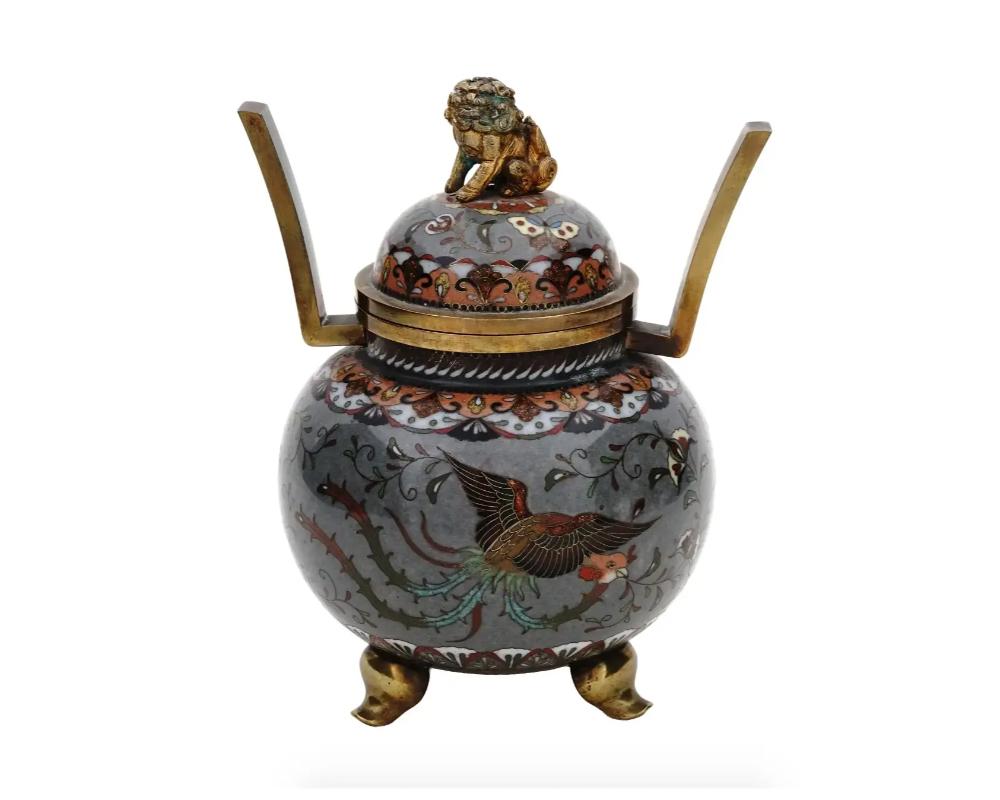 An antique Japanese Meiji Era tripod enamel metal censer koro. Circa: late 19th century. The sphere form ware is enameled with polychrome medallions with blossoming flowers and butterflies surrounded by floral and foliage patterns made in the