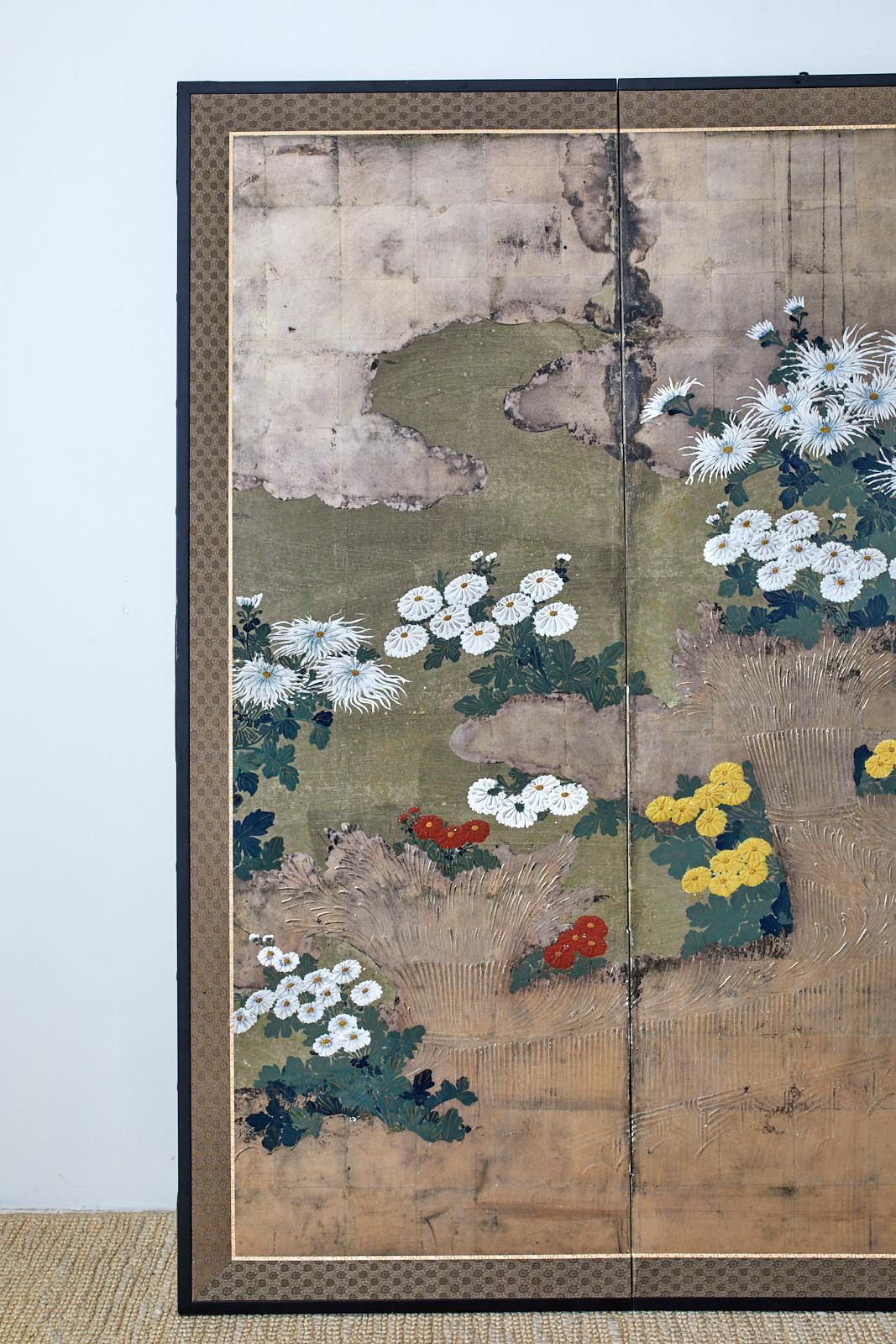 Extraordinary Japanese late Meiji period four panel screen depicting colorful chrysanthemums growing along a brushwood fence. The screen features extensive moriage (raised pigment) decoration on the fence and flowers that are difficult to appreciate