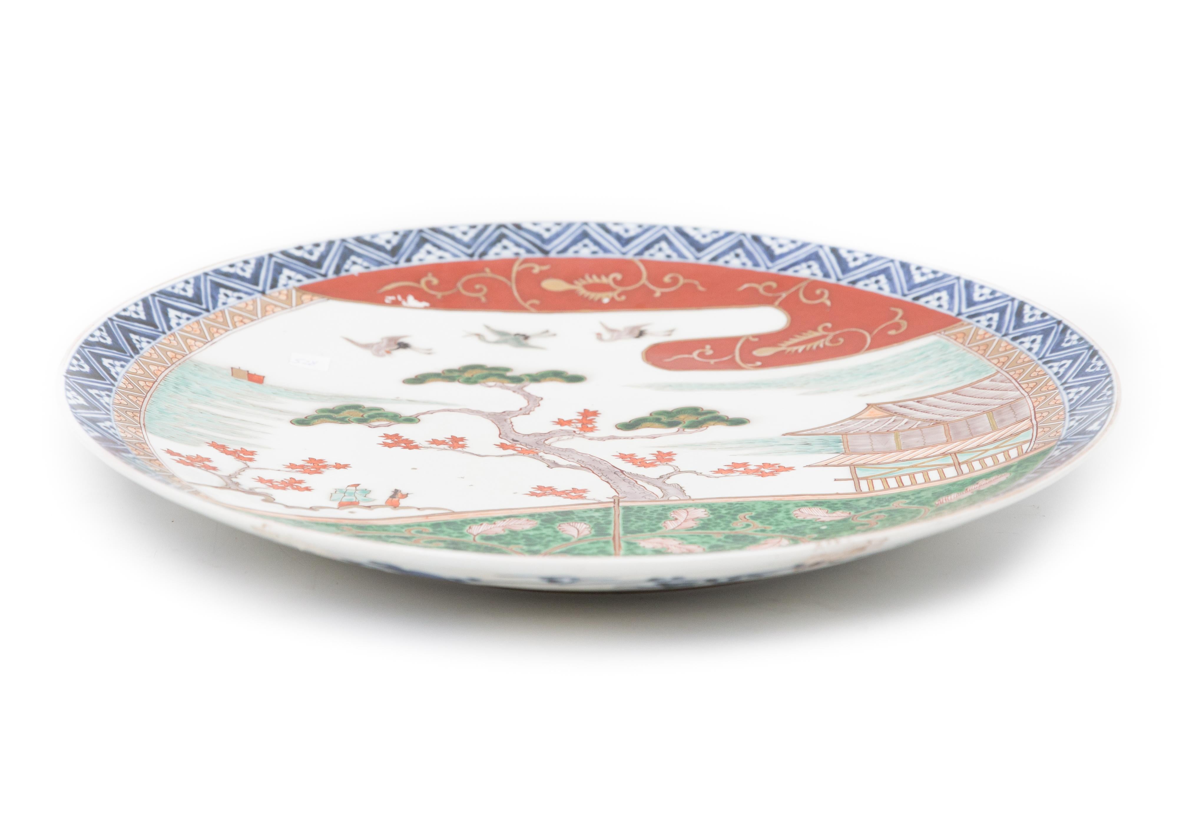 Offered is a large circa 1900 Japanese hand painted Imari ceramic charger. The piece is in good condition with two small areas where the red pigment glaze did not properly adhere to the substrate. The piece is large and measures 22” in diameter.