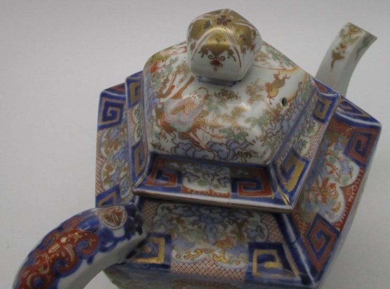 Exquisite Japanese large Meiji (circa 1880) decorative porcelain tea pot in a dramatic pentagon shape in vivid blue, red, turquoise and brown and generous gold details from the historic Imari-Arita region of Japan, boasting an auspicious Hyakunin