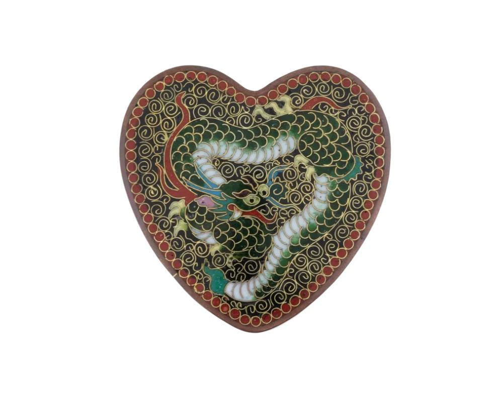 An antique Japanese, late Meiji era, Kyoto figural enamel over copper belt buckle. The heart shaped belt buckle is covered with a polychrome enamel design representing a dragon surrounded by swirl and geometrical ornaments made in the Cloisonne