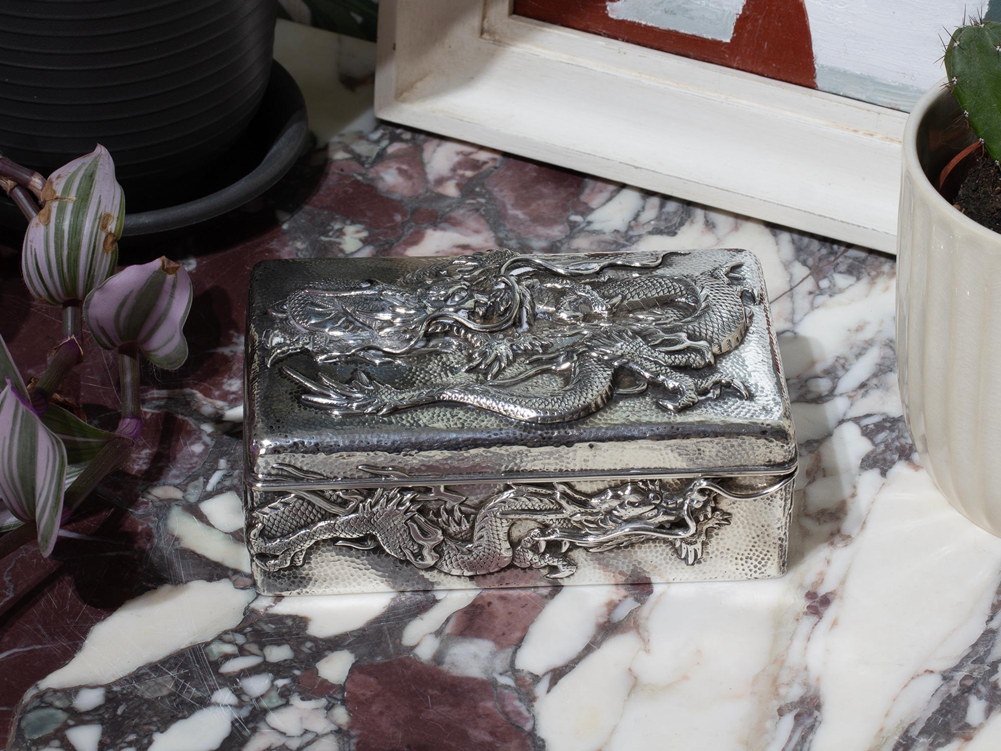 Gehämmertes Silber Dekoration gestempelt Jungin reinem Silber 純銀

Wir freuen uns, Ihnen aus unserer japanischen Sammlung eine japanische Dose mit einem silbernen Drachen aus der Meiji-Zeit anbieten zu können. Die Dose mit rechteckiger Form ist aus