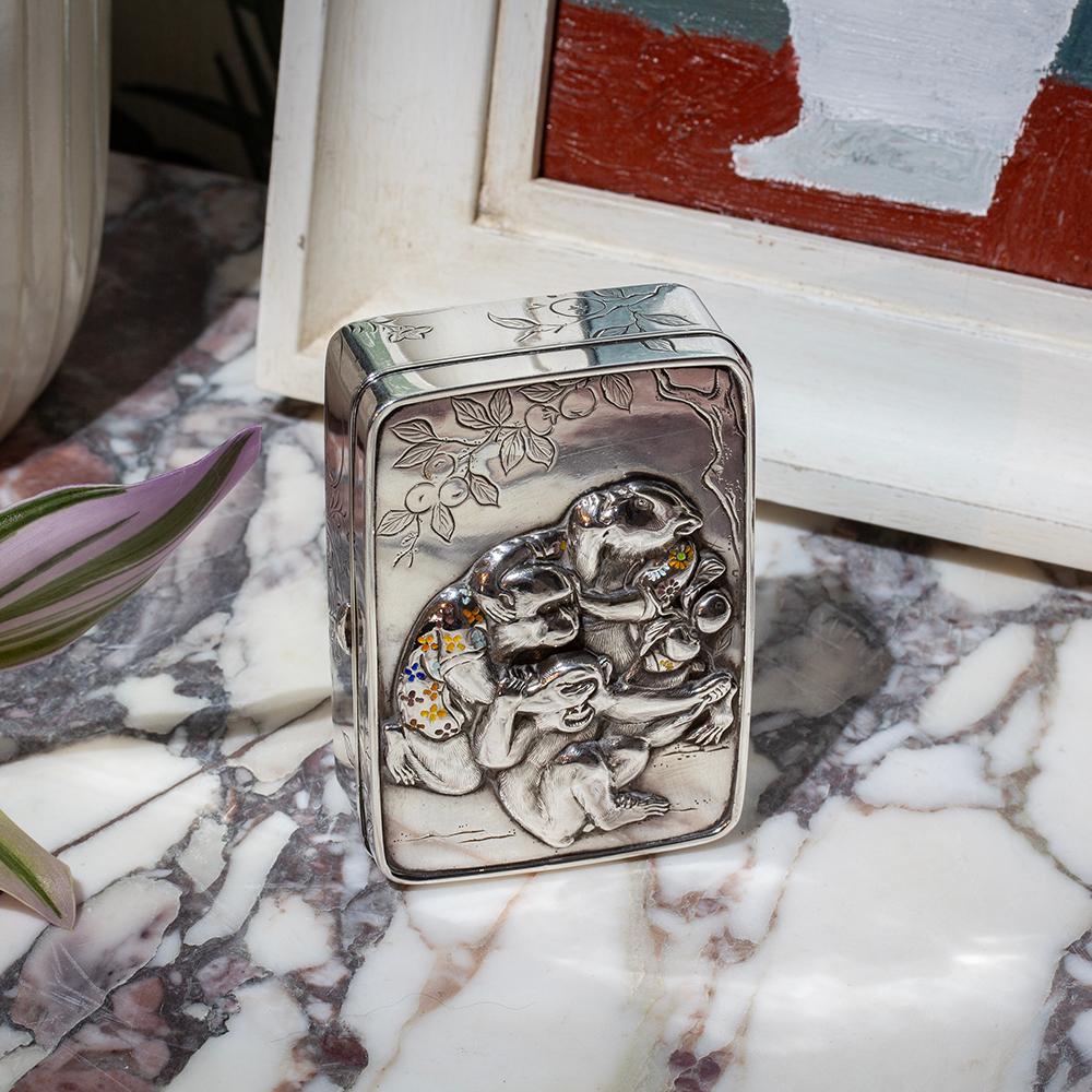 The Silver box of rectangular form with rounded corners features the Three Wise Monkeys to the front, see no evil, hear no evil and speak no evil. The monkeys cast beautifully with naturalistic features wearing humorous enamelled haori (羽織). The box