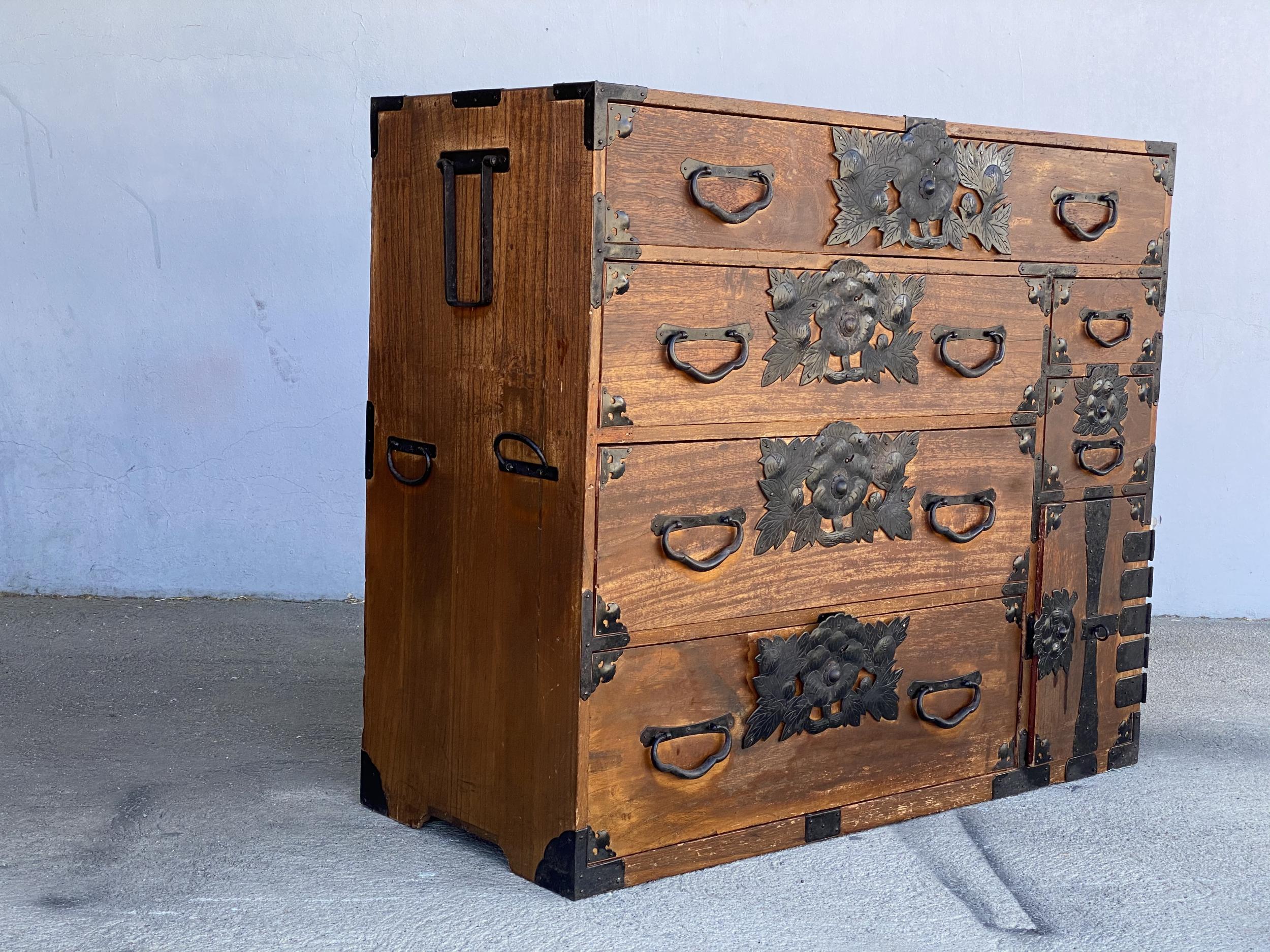 19th century Meiji period Keyaki wood Tansu ten-drawer clothing chest. The chest features 4 large drawers, 2 small side drawers, and a small cabinet on the lower right which opens to 4 smaller drawers. One drawer within this cabinet has a skeleton