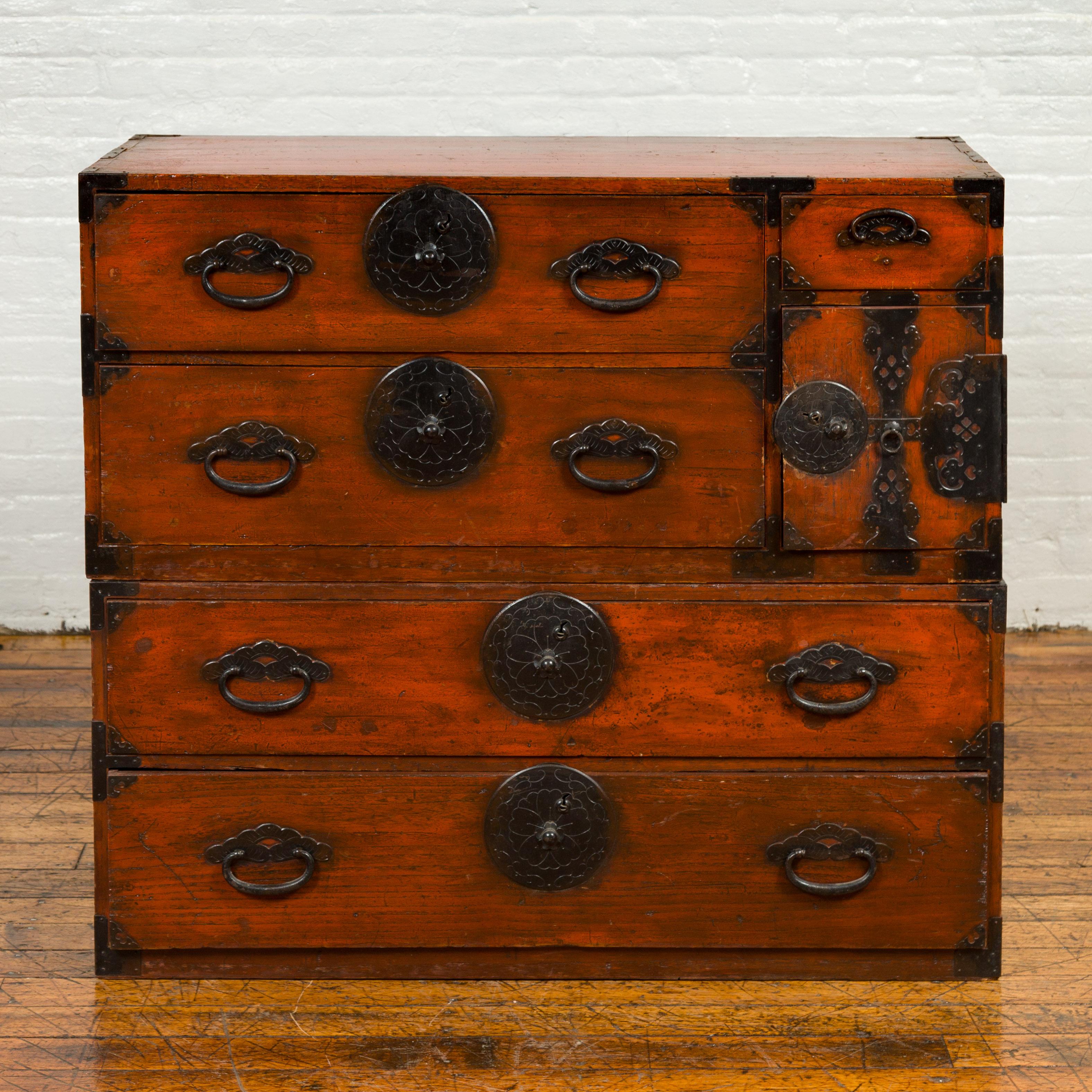 A Japanese Meiji period tansu clothing chest in the Sendai Isho-dansu style, with hand-cut iron hardware. Born during the 19th century, this wooden tansu is a fine example of Japan's traditional mobile cabinetry. Featuring a lacquered finish with