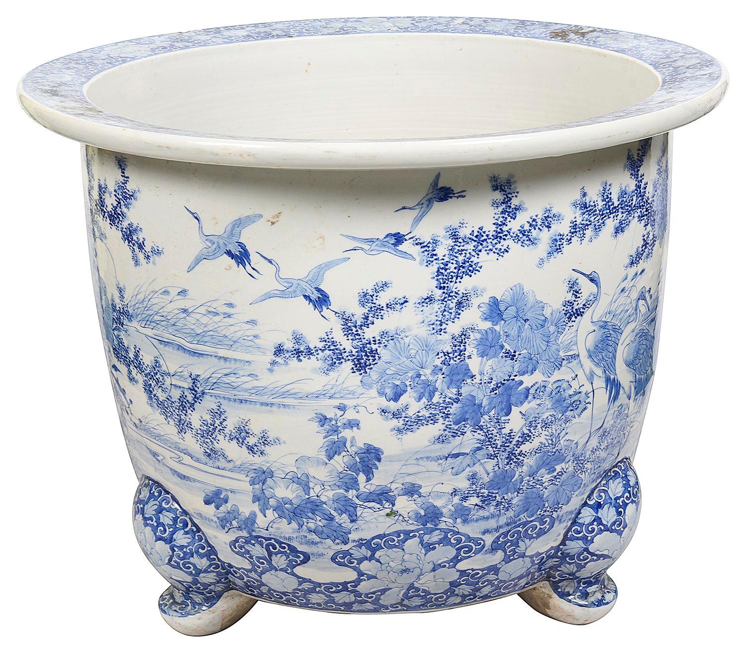 A very decorative late 19th Century Japanese Blue and White porcelain jardiniere, depicting classical lake side scenes with exotic birds, flowers and blossom trees. Raised on delicate scrolling feet.

Batch 82 YEKZ RN