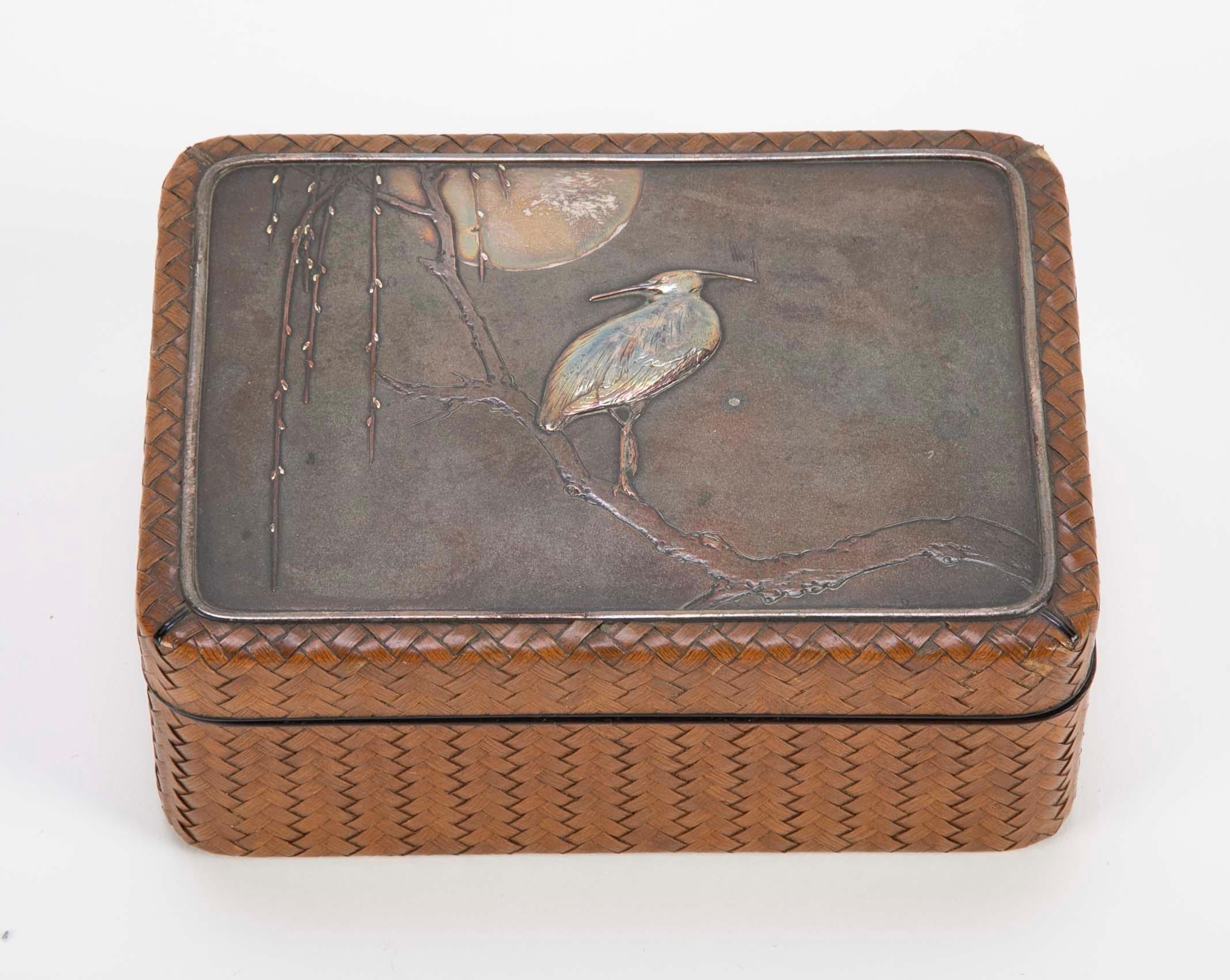 Japanese Meiji Period box of woven cane, lacquer, silver & copper depicting an egret on a branch under the moon on the lid. circa 1868-1912.