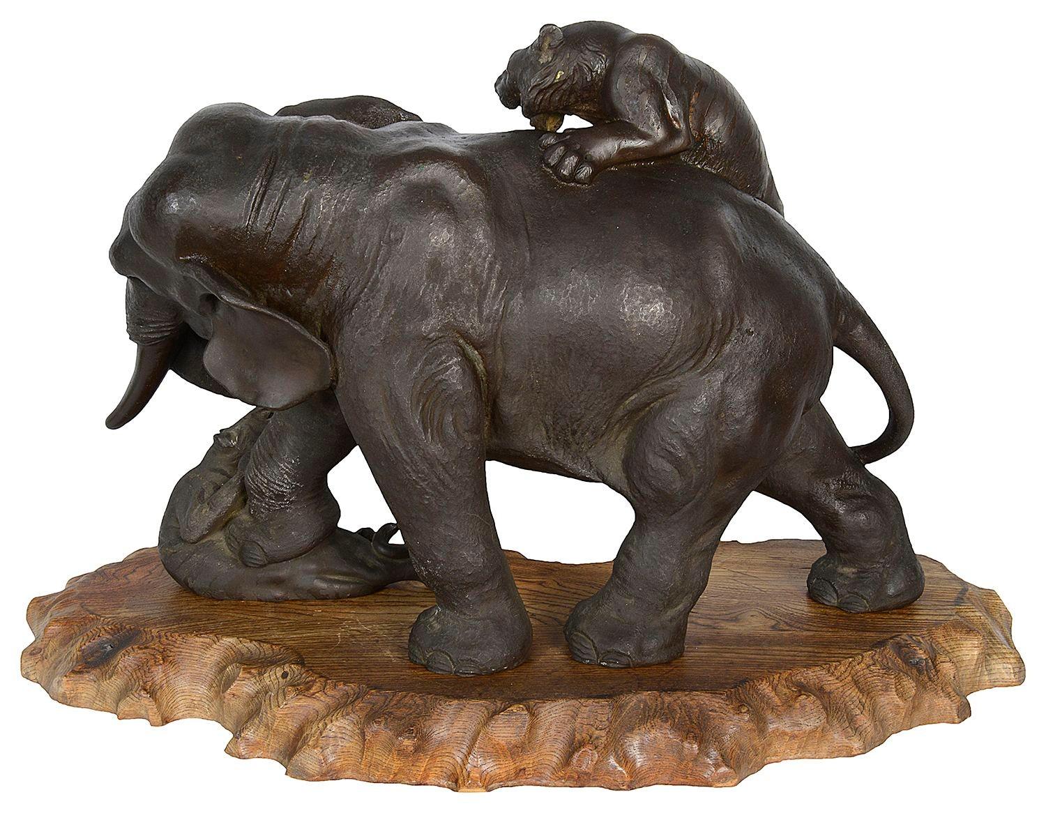 A fine quality Dramatic late 19th Century Japanese Meiji period (1868-1912) patinated bronze Elephant being attacked by two Lions, set on a carved wooden base, signed to the underside.


Batch 75. 62045