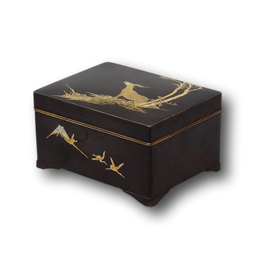 CON INCRUSTACIONES DE UN CIERVO DE ORO Y PLATA

De nuestra colección japonesa, tenemos el placer de ofrecerte esta Caja Damascena Japonesa de Ashizuki. La Caja Japonesa de forma rectangular elevada sobre cuatro patas perfiladas presenta un fondo