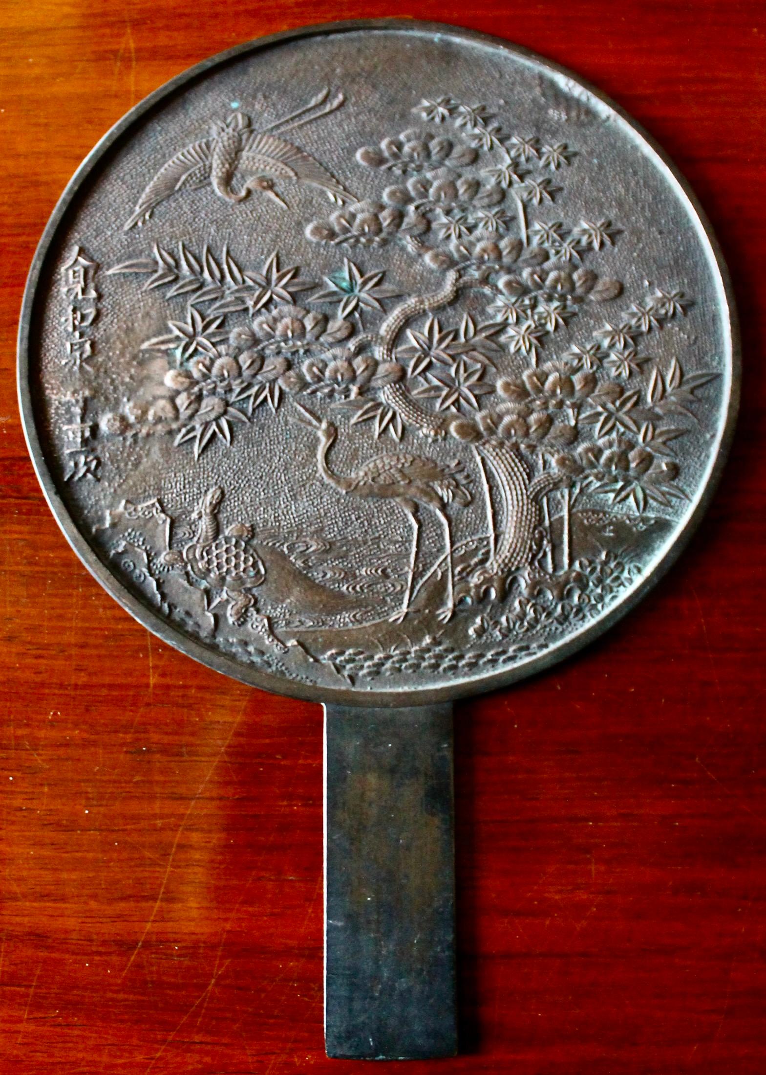 Meiji period cast bronze hand mirror.  Very fine casting quality depicting
typical Japanese motifs.