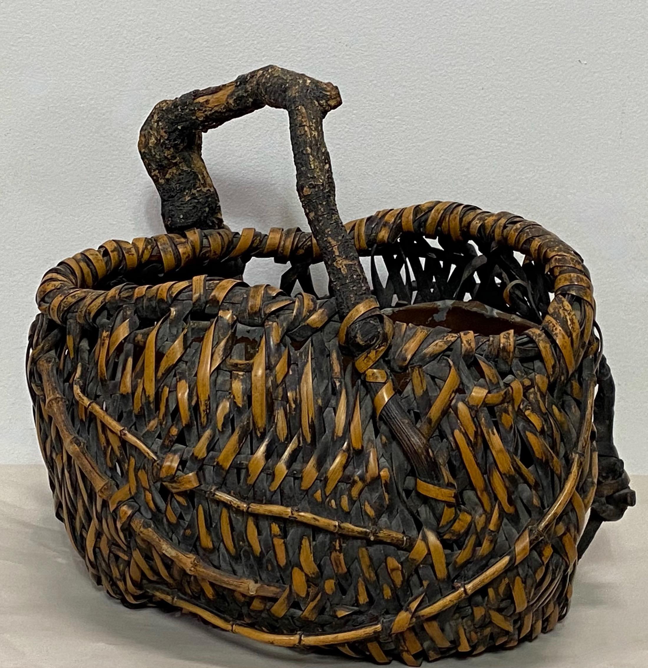 An extraordinary one of a kind 19th century Japanese bamboo ikebana basket having its original tin liner, (tin liner holds water).
Beautiful rich warm texture and organic character. 
Meiji period, Japan.
In excellent antique condition.


 