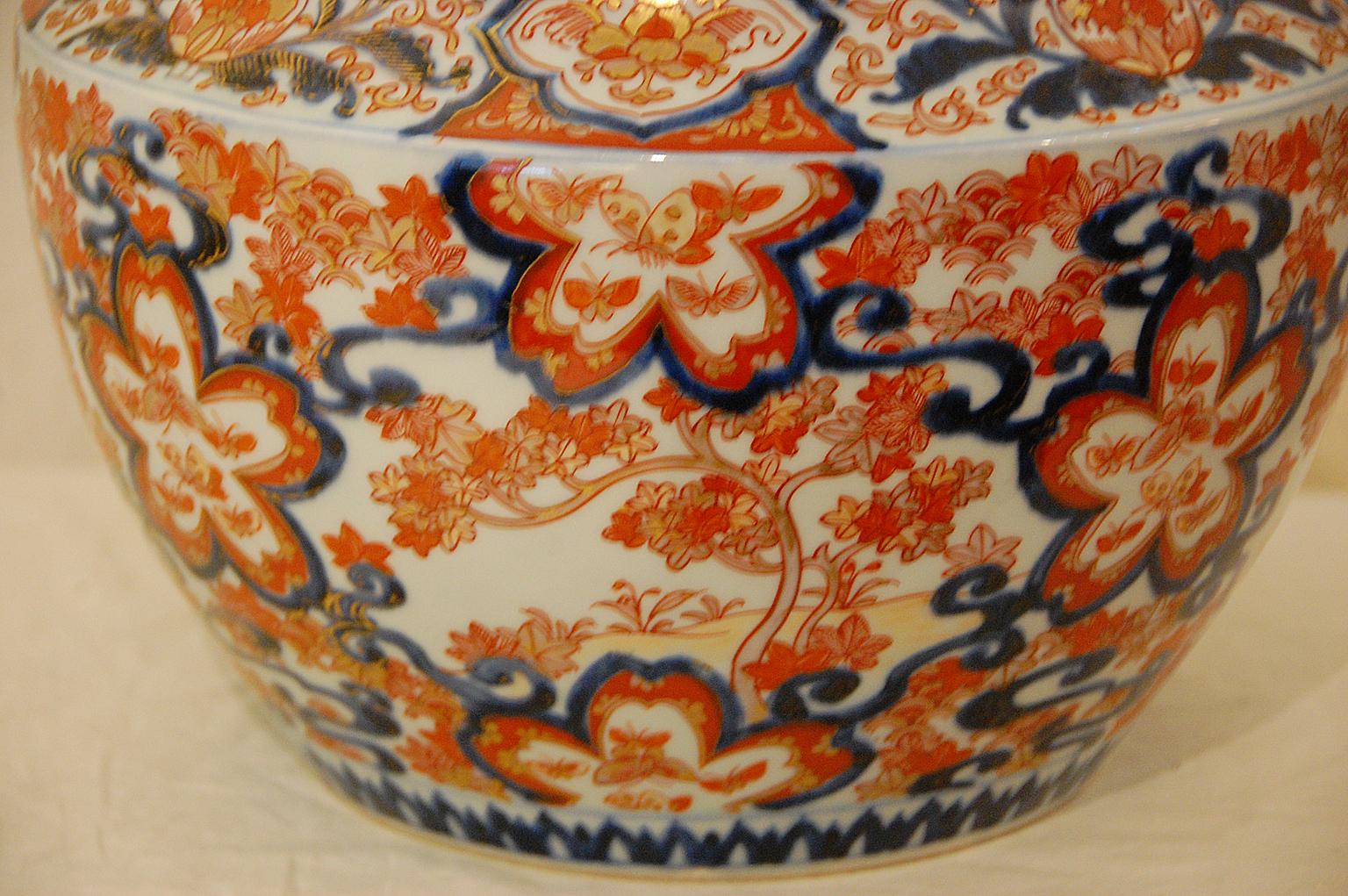 Japanese Meiji period imari jardinière with maple tree and butterfly motifs. This hand painted porcelain has underglaze blue decoration with overglaze enamels in rusts and gold leaf, circa 1870-1880. The diameter of the opening is 9 inches, the