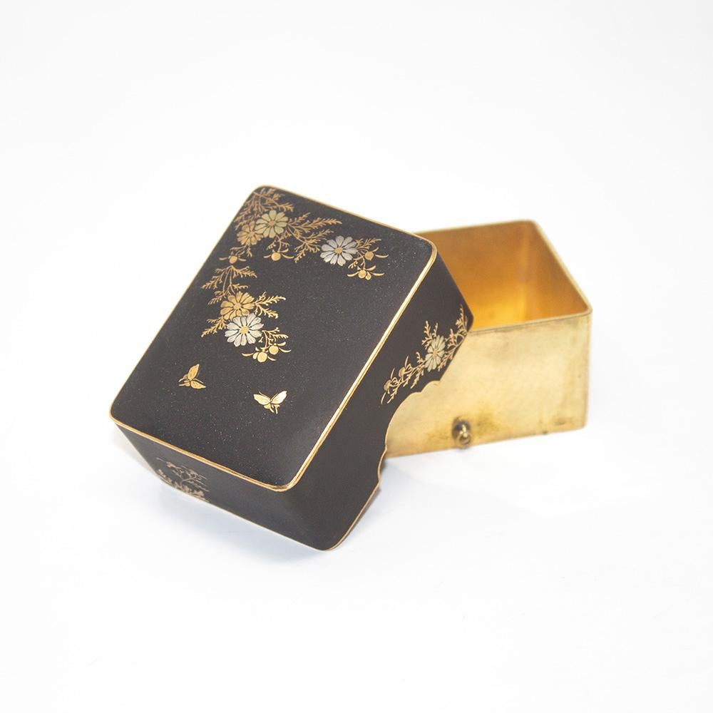 Fine Japanese Meiji period Komai style damascene box. The box with twin loop handles to the base with a inlaid damascene lid encompassing the brass body. Decorated with floral sprays throughout and two butterflies to the top.