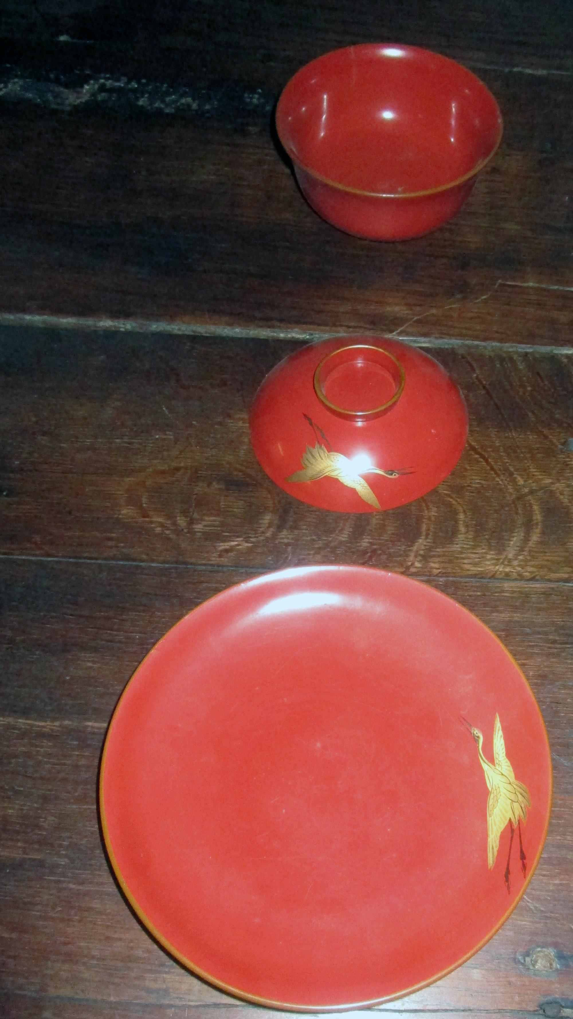 This lovely 14 piece set of Japanese Meiji period (1868-1912) Lacquerware consists of a large platter, serving bowl, and four rice bowls each with saucers and lids. The applied gold Maki-e cranes or Tsuru are a symbols of good luck, longevity, hope,