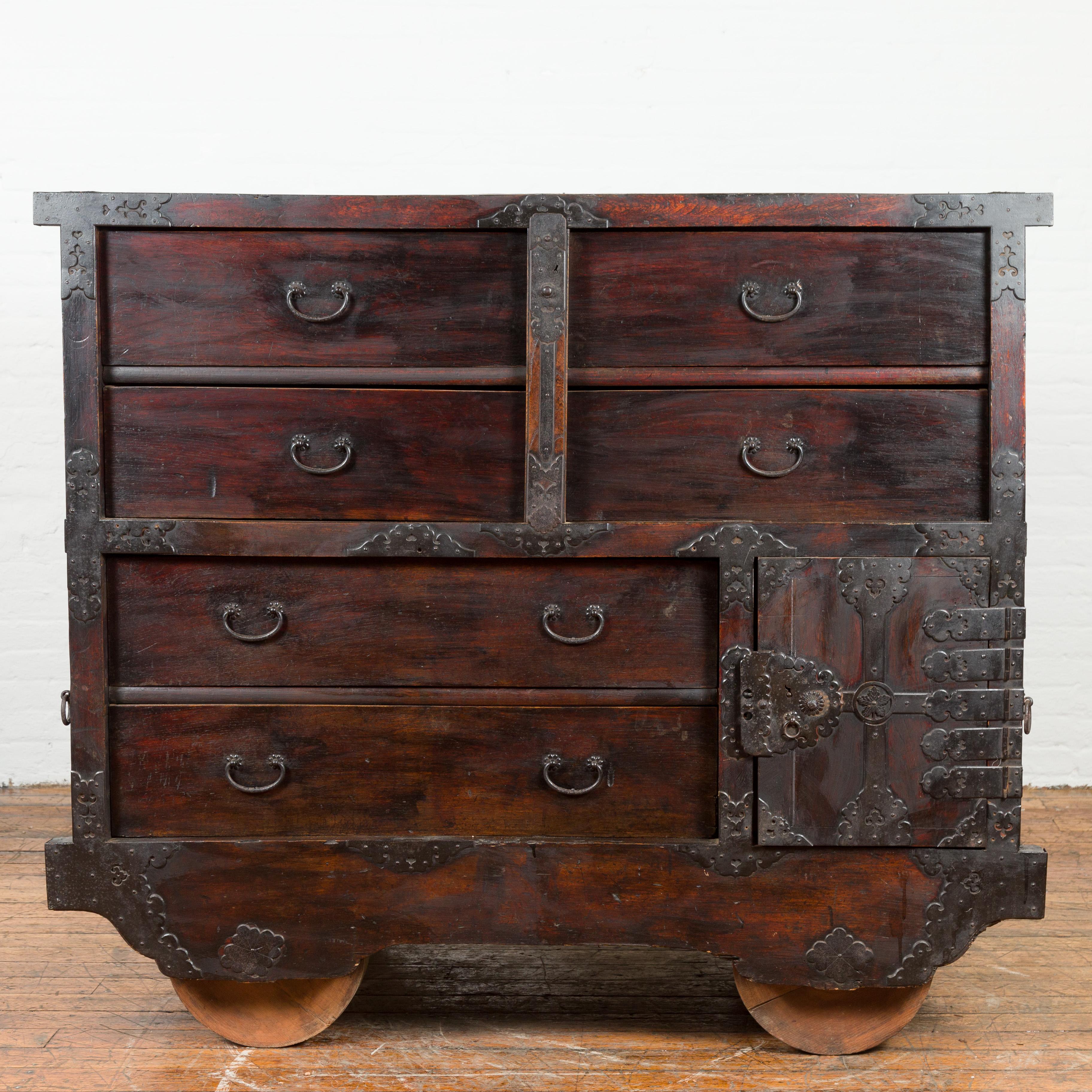A Japanese Meiji period merchant's chest on wheels from the late 19th century, with safe and iron hardware mounted on wheels. Created in Japan during the later years of the 19th century, this merchant's chest features six large drawers and a safe