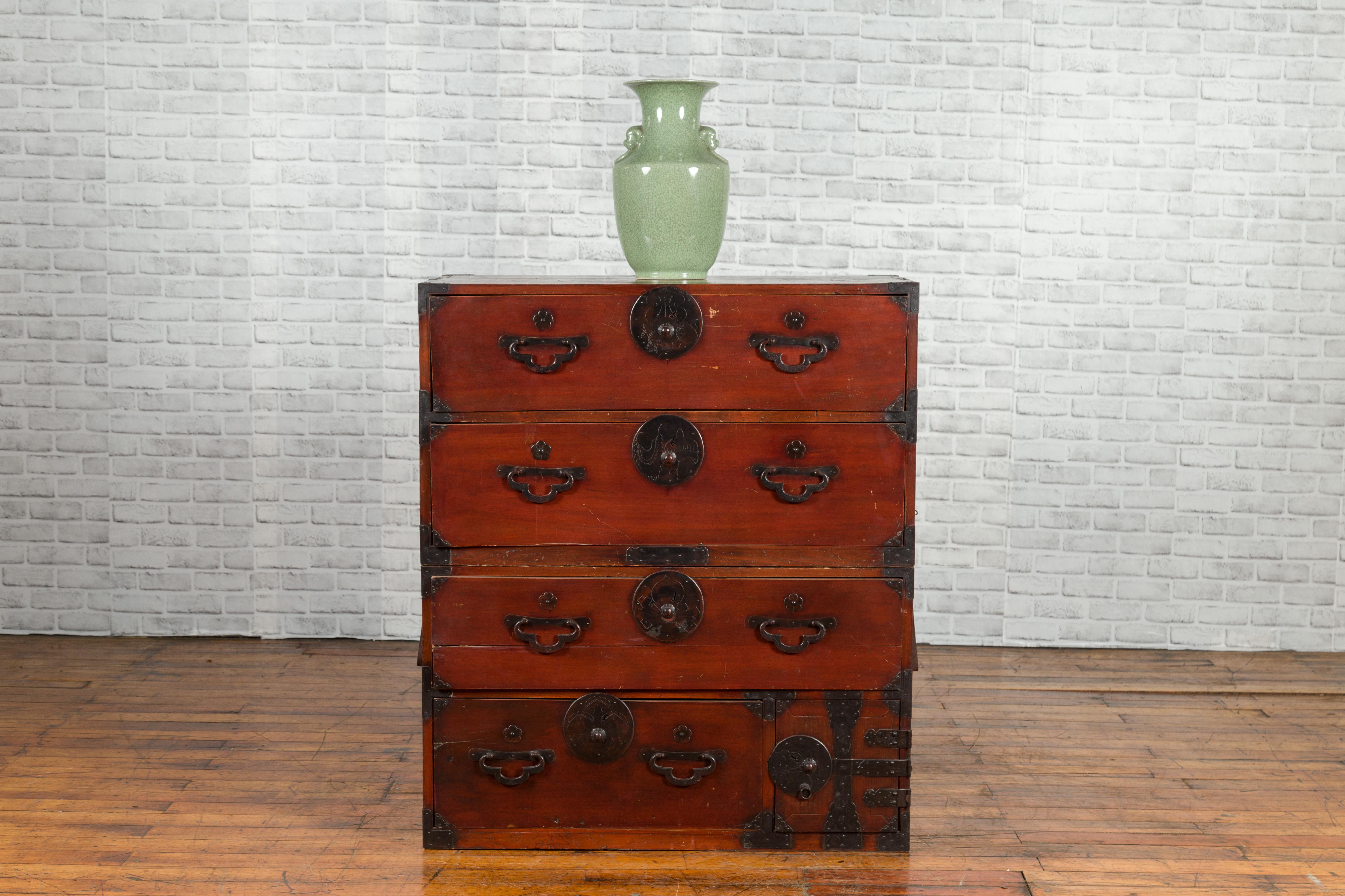 A Japanese Meiji period tansu chest from the late 19th century in the Sendai Isho-dansu style, with reddish brown lacquer and iron hardware. Created in Japan during the Meiji era (1868-1912), this tansu chest features a reddish brown lacquer