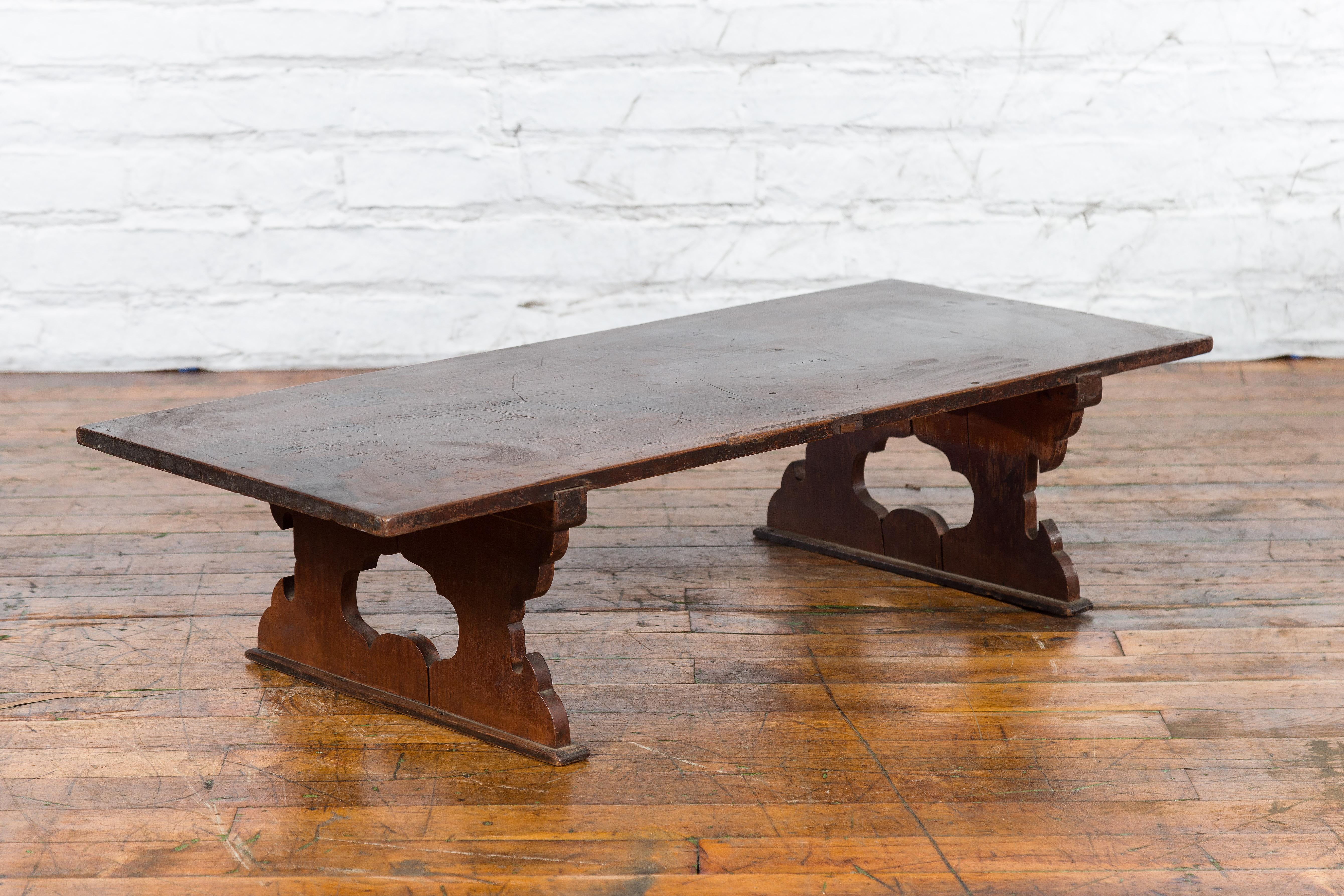 A Japanese Meiji period low table from the early 20th century, with recessed legs and open carved cutout design. Created in Japan during the Meiji era where is was used as a low writing table, this piece features a rectangular top overhanging two